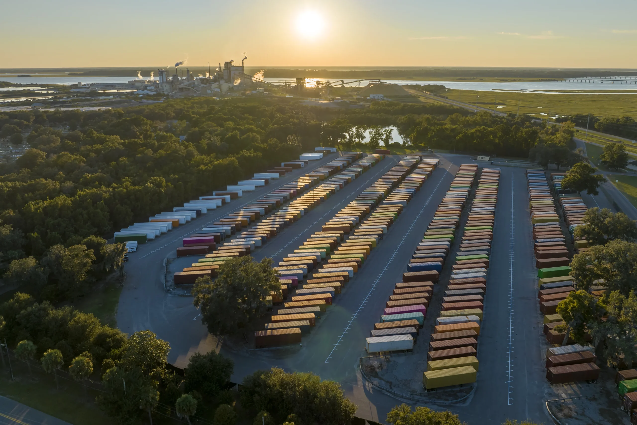 Aerial view of a cargo container yard at a cross dock center with rows of containers.