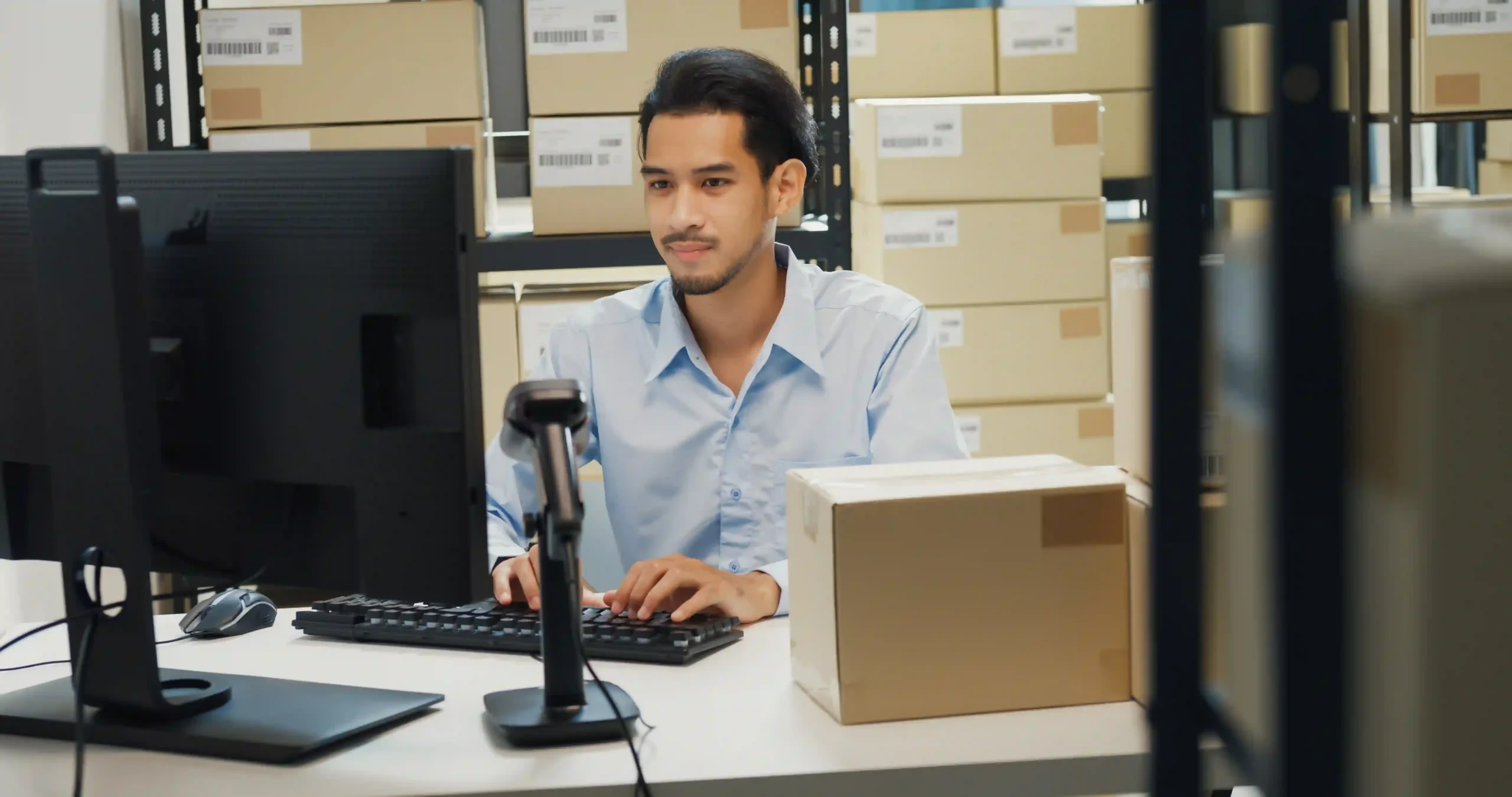 Logistics professional reviewing inventory data on a computer using an inventory management system questionnaire.