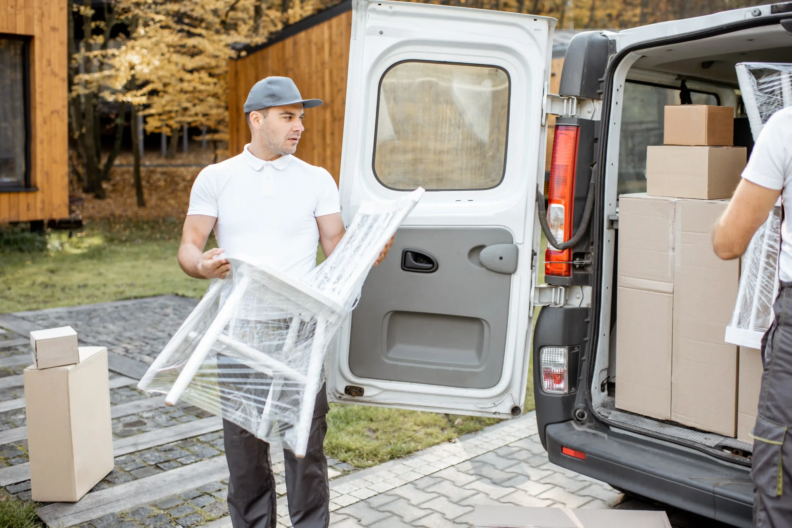 A logistics worker unloading a wrapped chair during a contract furniture transport delivery for a commercial project.