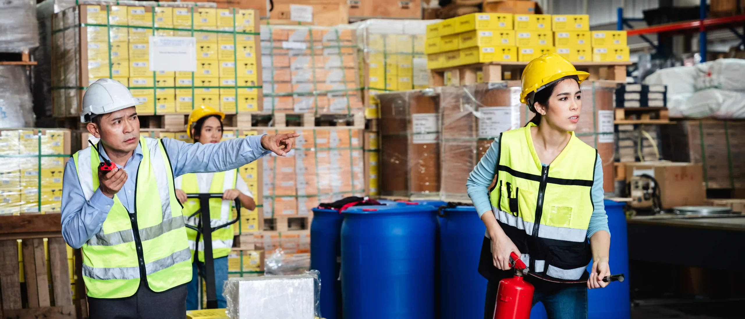 Warehouse safety team responding to a hazardous materials emergency with fire extinguishers.