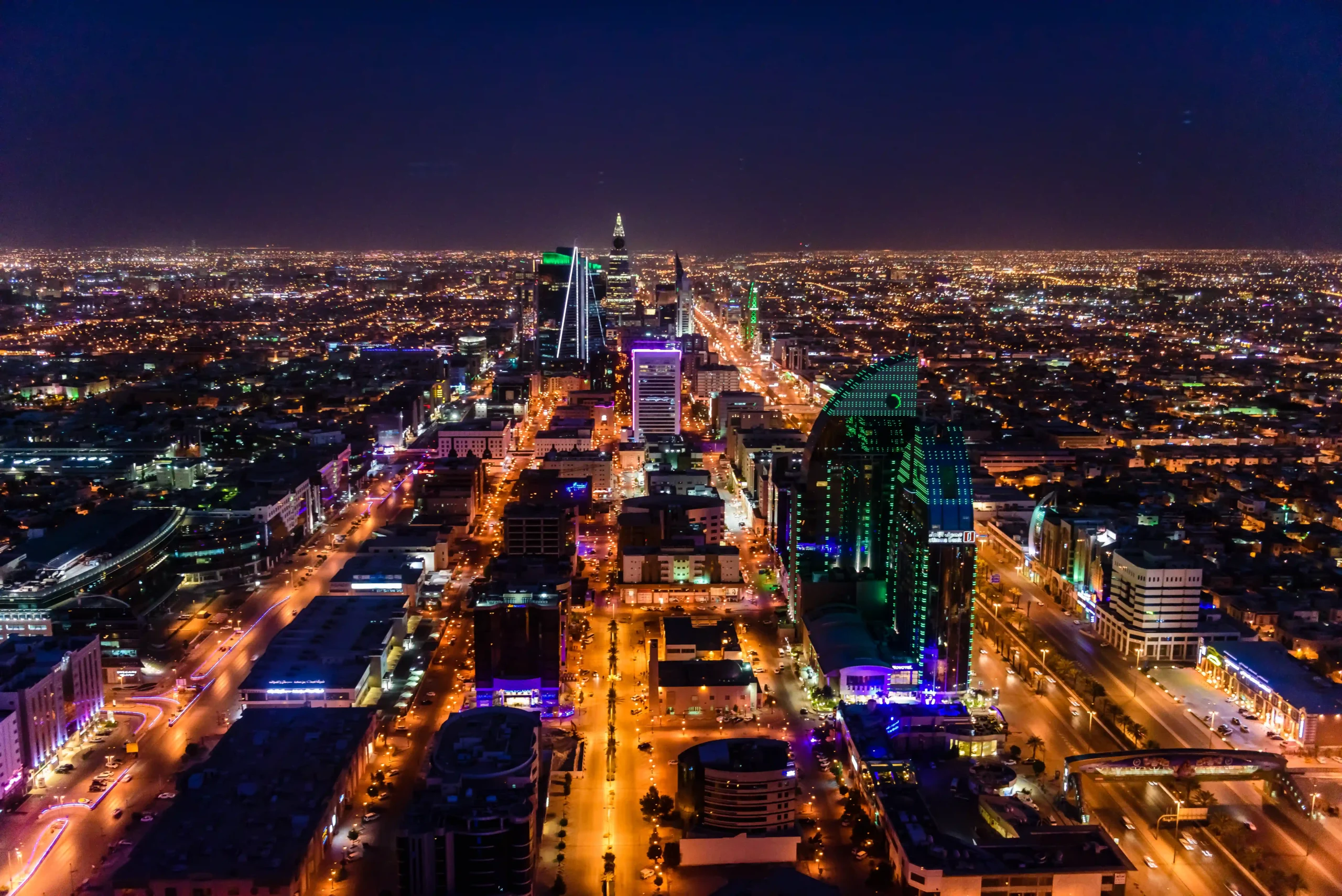 Aerial view of Riyadh's illuminated cityscape, showcasing international trade and logistics infrastructure.