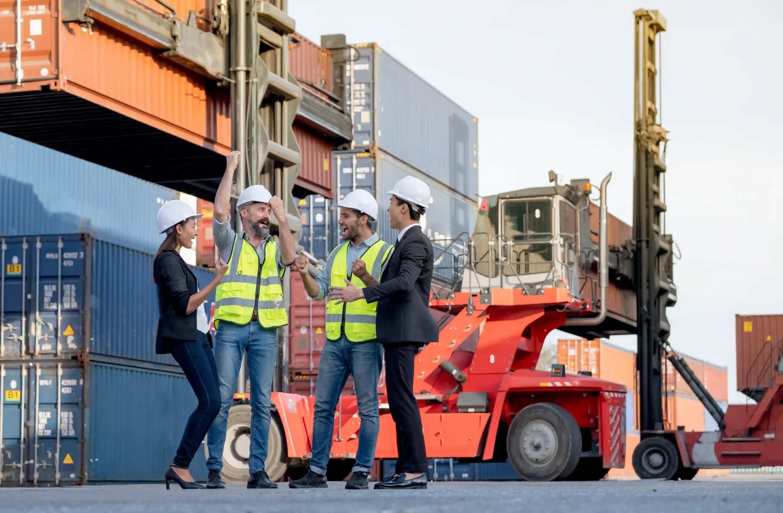 Logistics team celebrating successful cargo handling with container stacks in background — showcasing 3PL value added services in action.