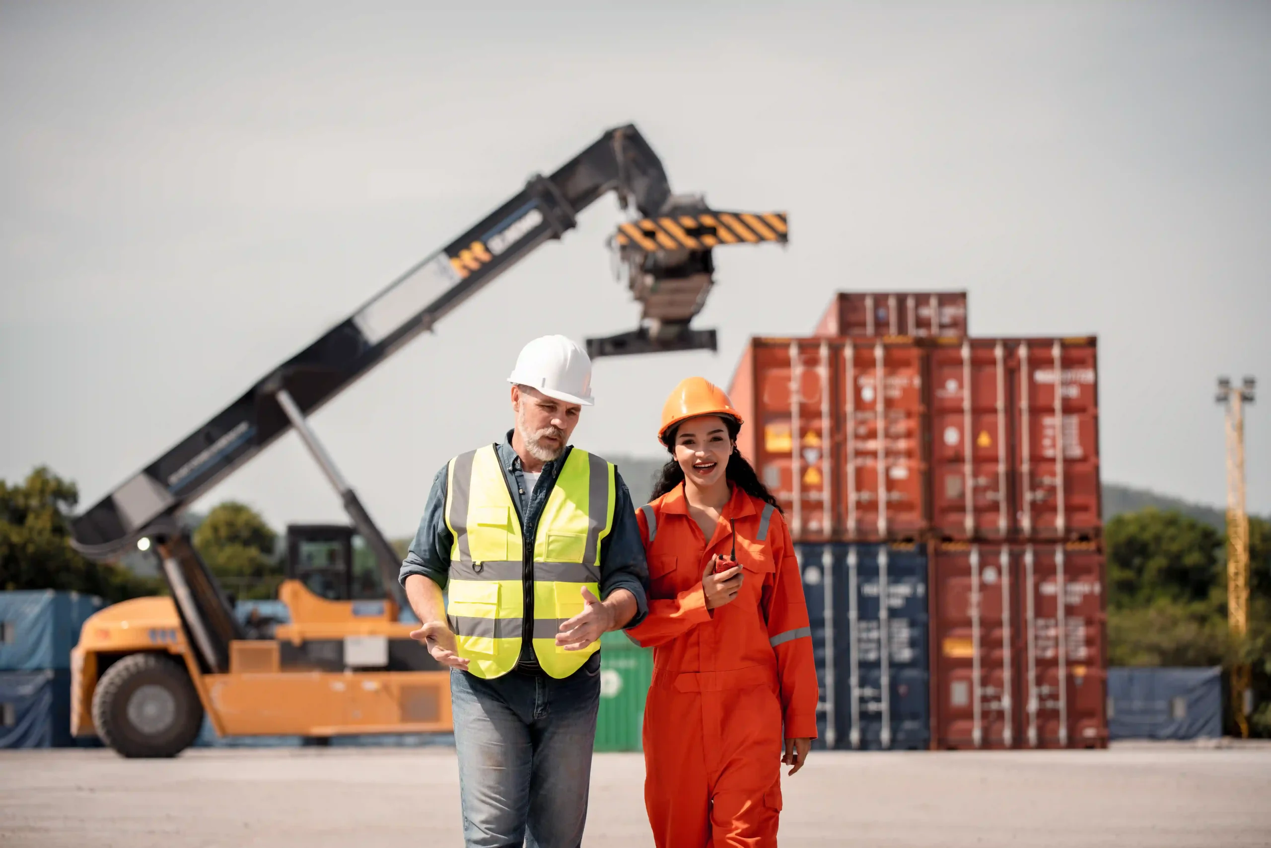 Logistics engineers discussing operations under new international shipping regulations 2025 at a freight yard