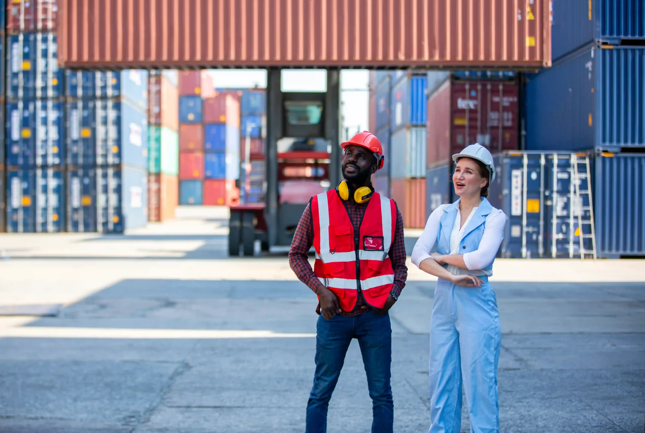 Two logistics professionals coordinating freight container movements at a 3PL freight services hub