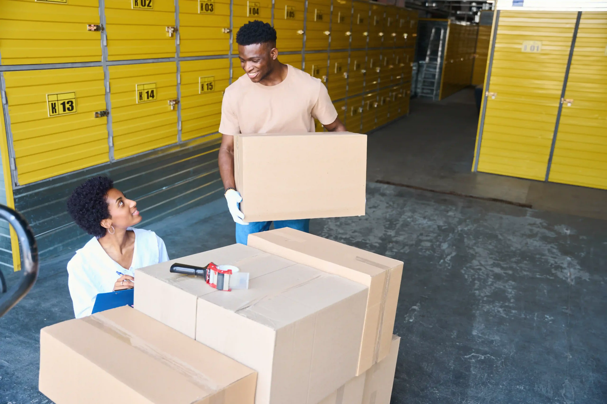 3PL team unloading cargo boxes into organized storage to control pallet storage cost in a logistics facility.