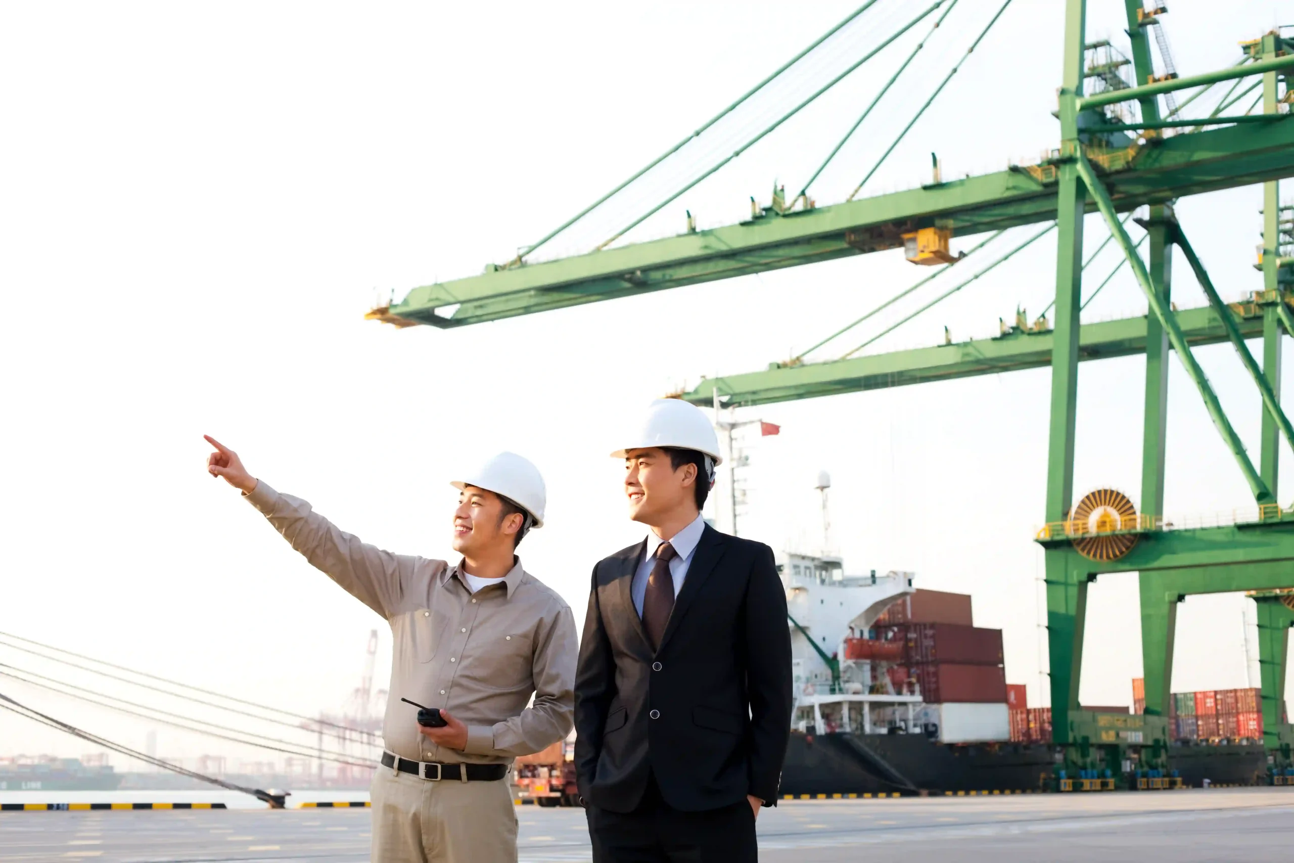 Logistics executive and port worker reviewing infrastructure under international shipping regulations 2025