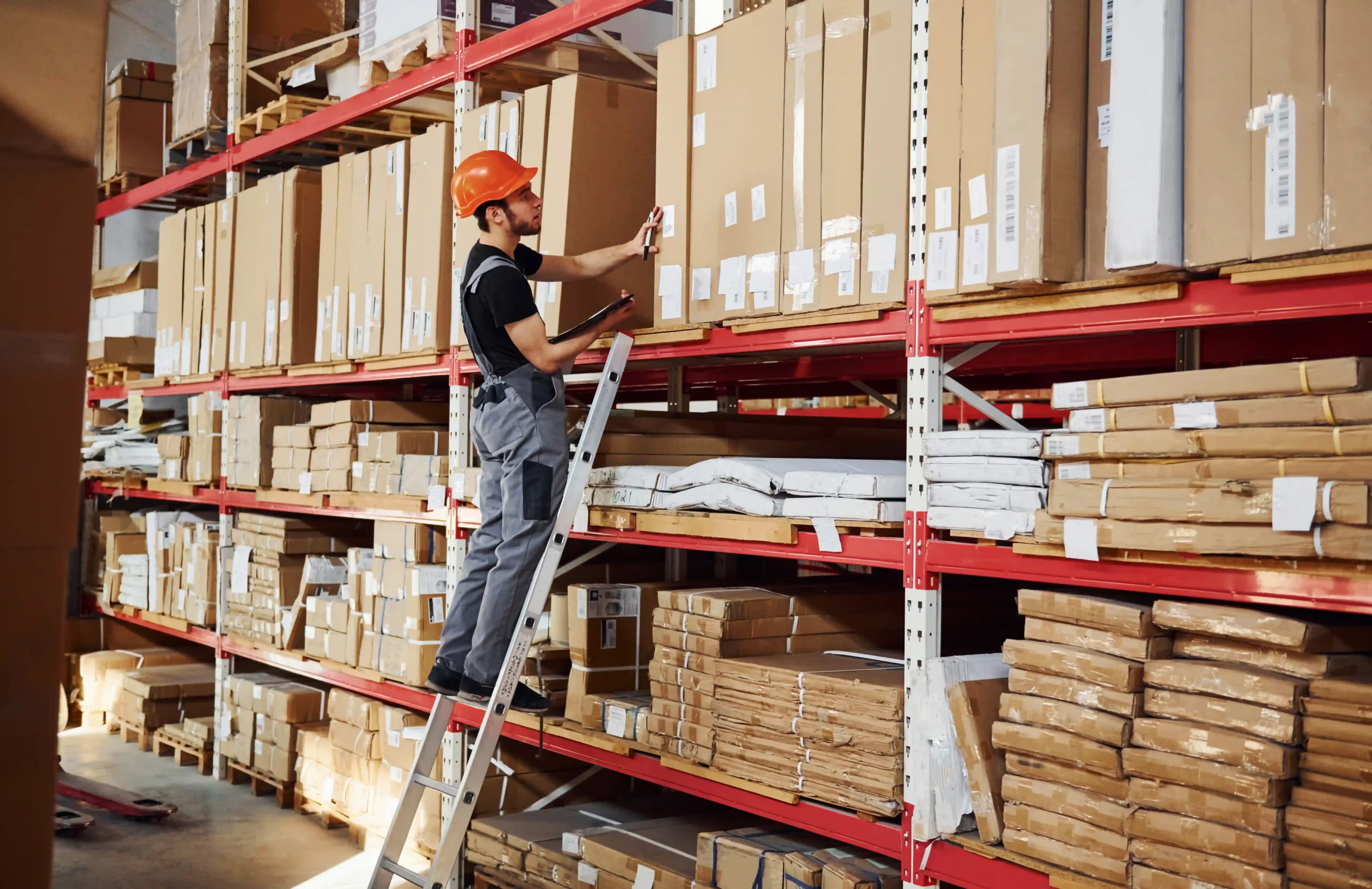Warehouse employee managing inventory on high racks using 3PL warehouse solutions
