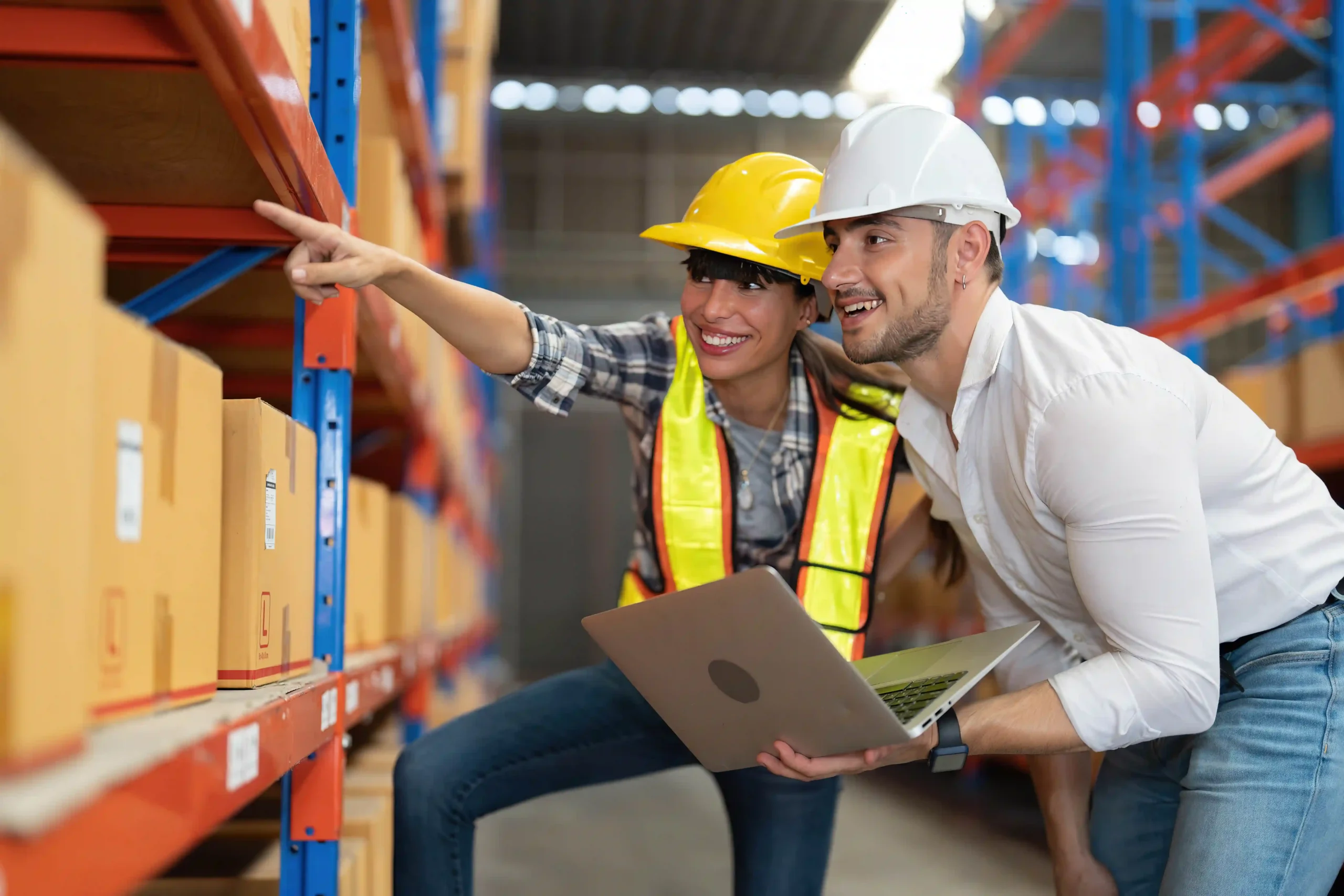 Warehouse supervisor and manager reviewing inventory shelves on a laptop, showcasing digital integration in warehousing for dummies.