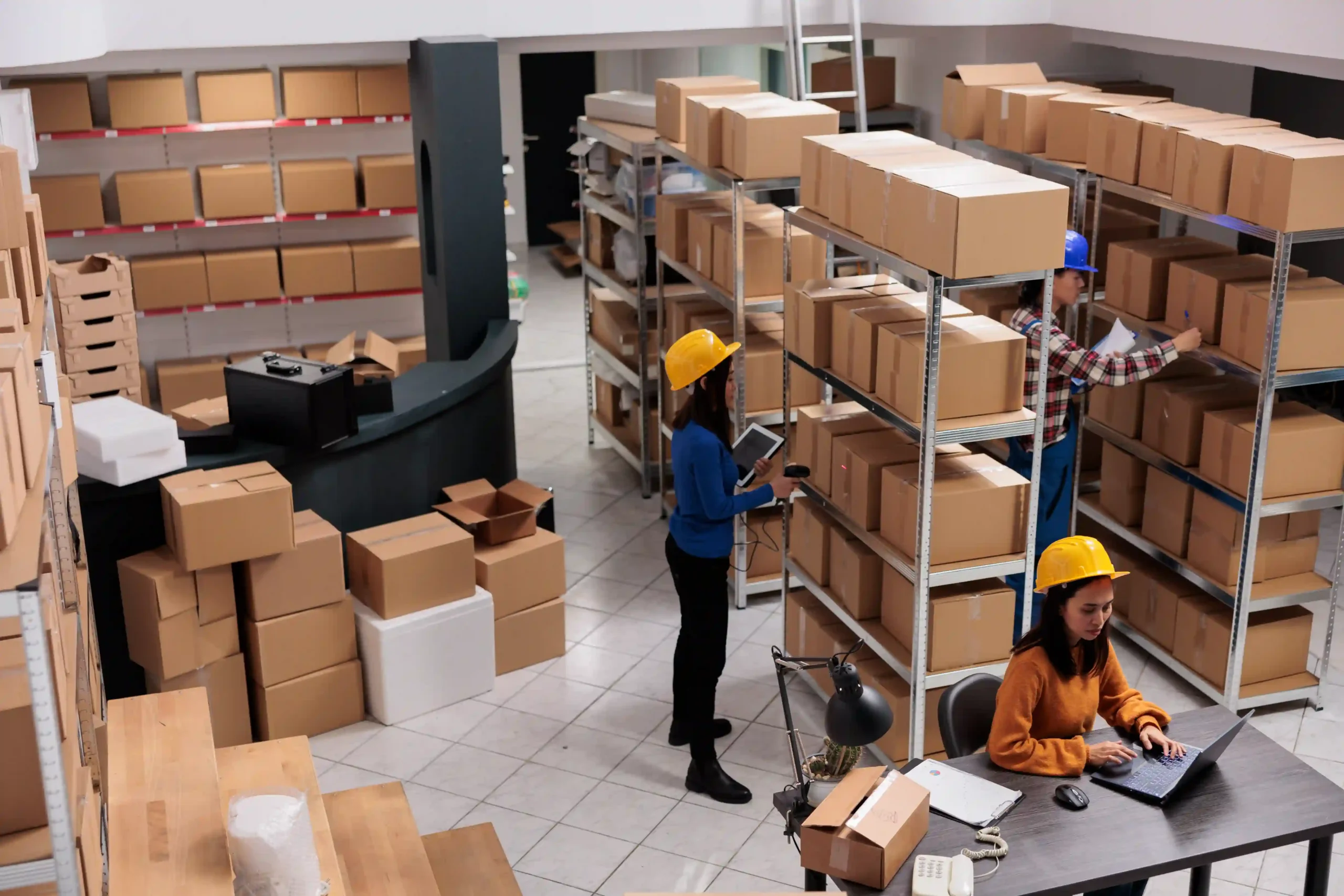 Warehouse fulfillment team organizing inventory and performing order processing in warehouse with handheld scanners.