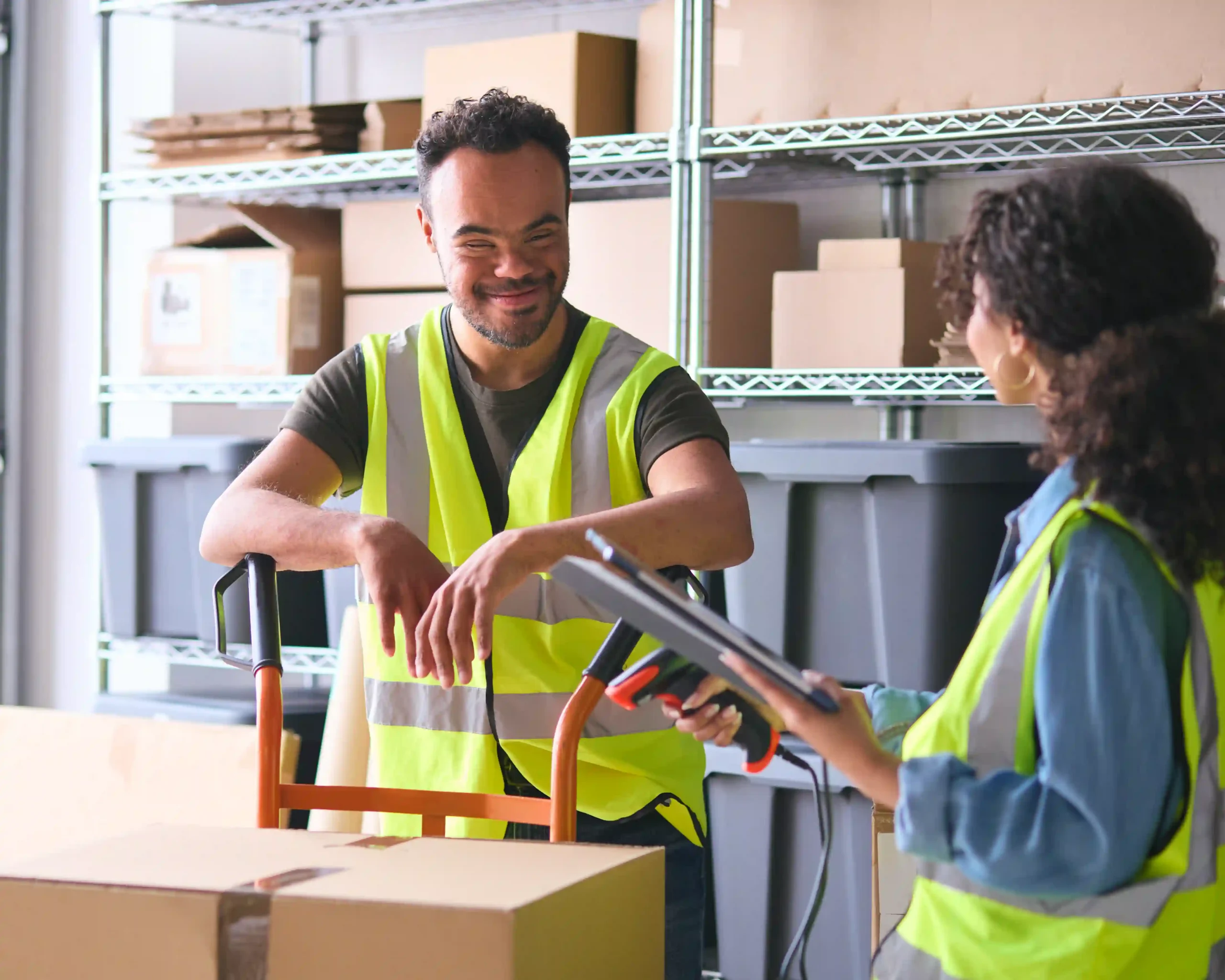 Warehouse workers using a tablet and scanner for product tracking, highlighting modern tools in warehousing for dummies strategies.