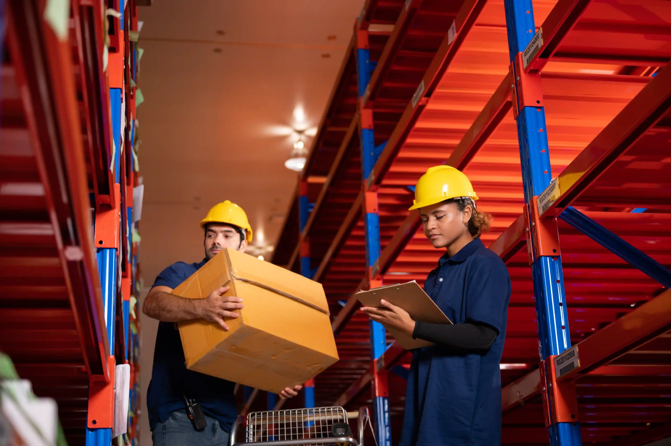Worker organizing shipments in storage aisles, representing a warehousing cost example of operational flow