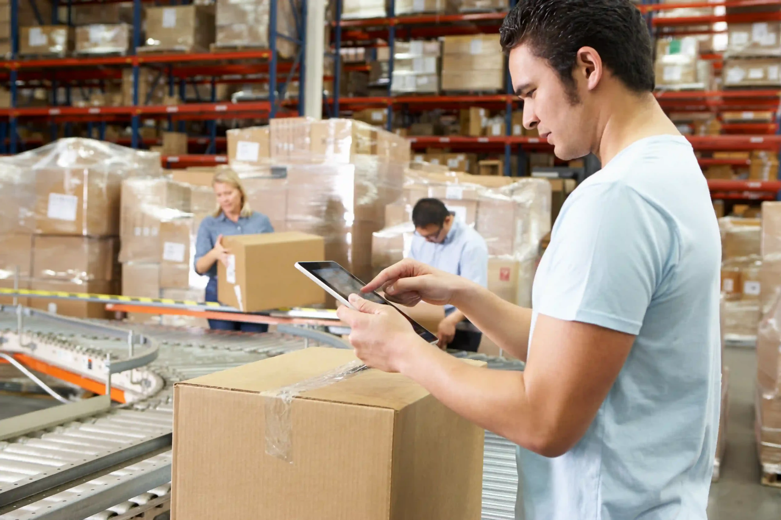 Warehouse worker using a tablet for order processing in warehouse to improve efficiency and accuracy.