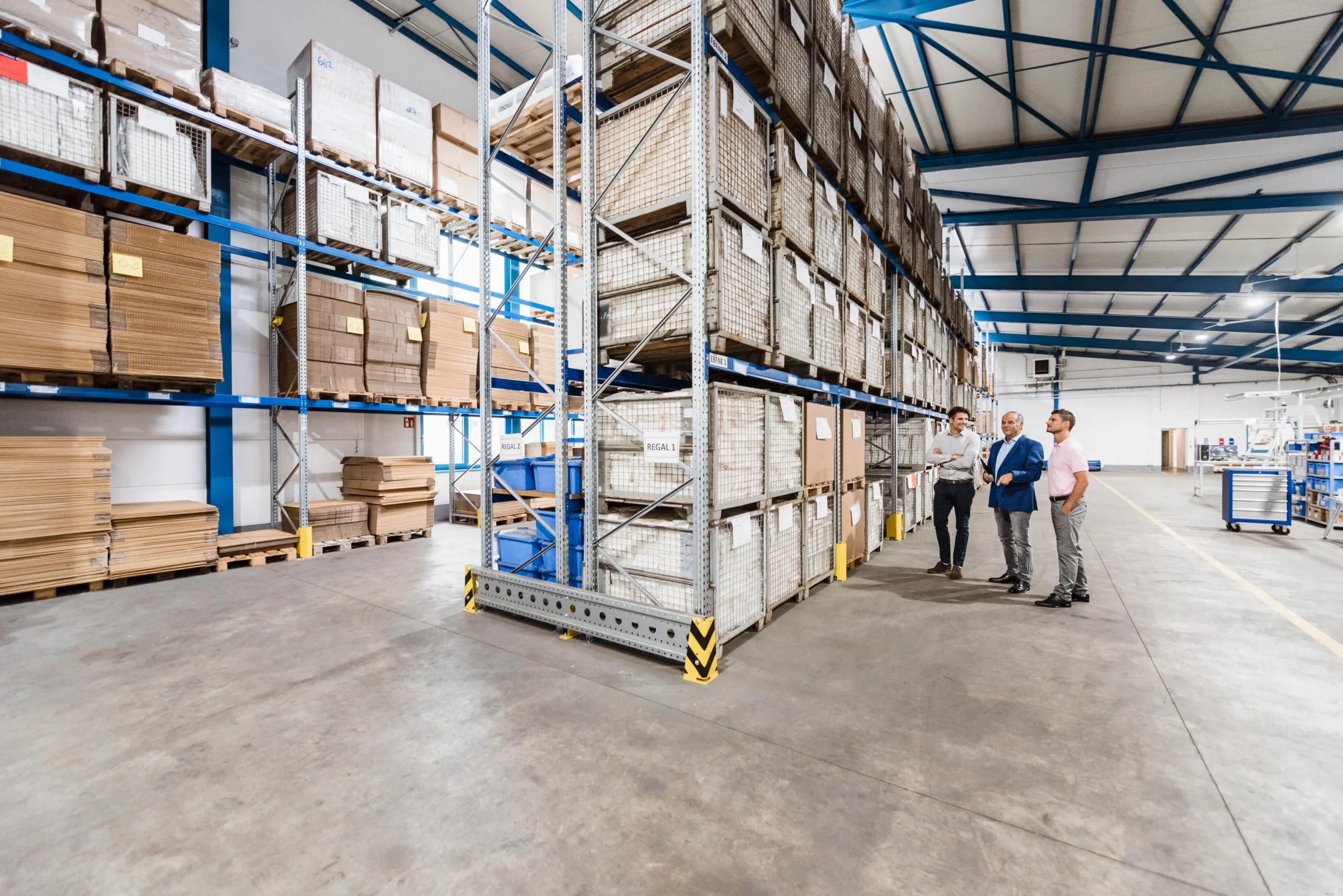 Business professionals inspecting inventory in a modern warehouse storage facility.