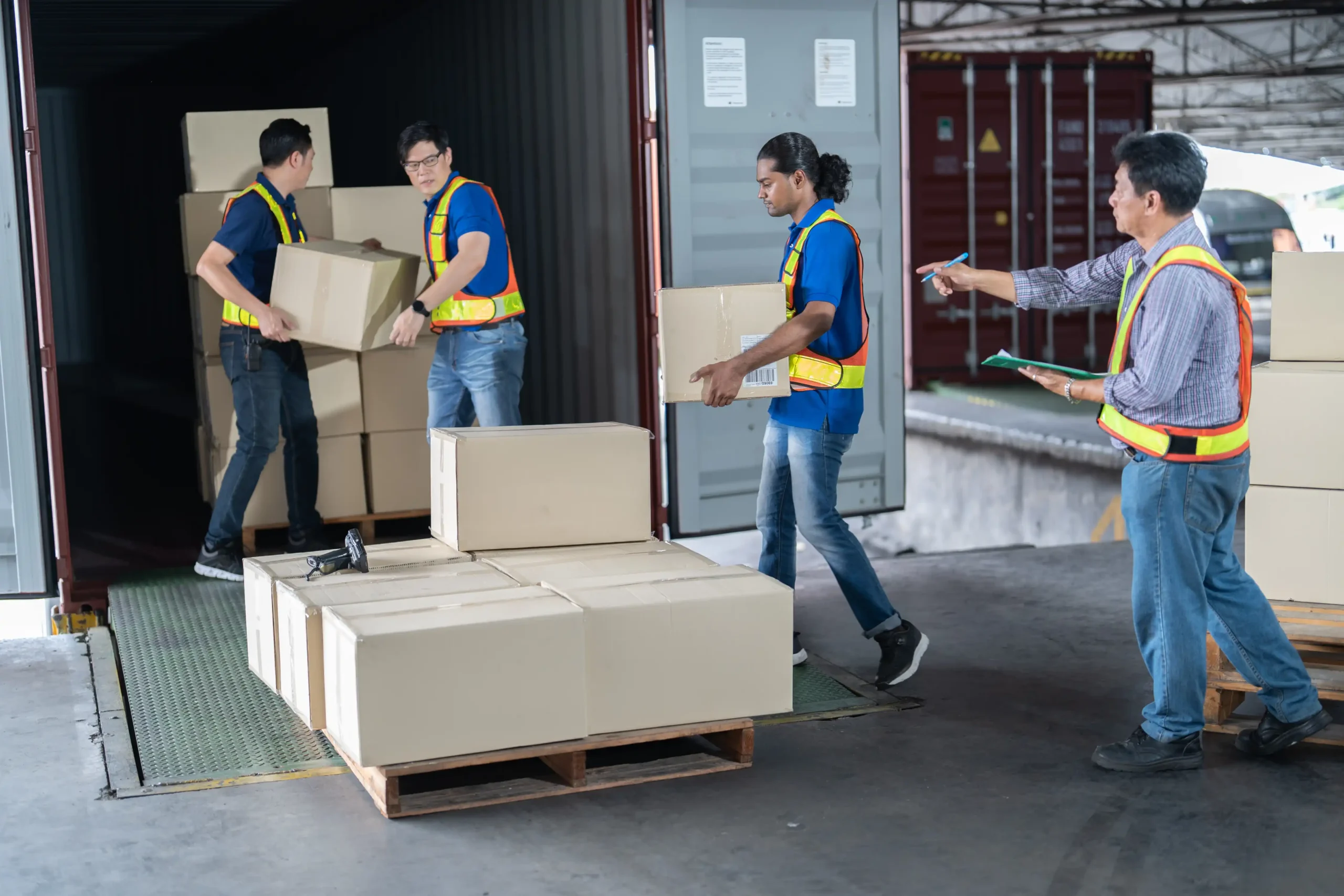 Warehouse workers unloading boxes from a shipping container as part of specialized logistics operations.