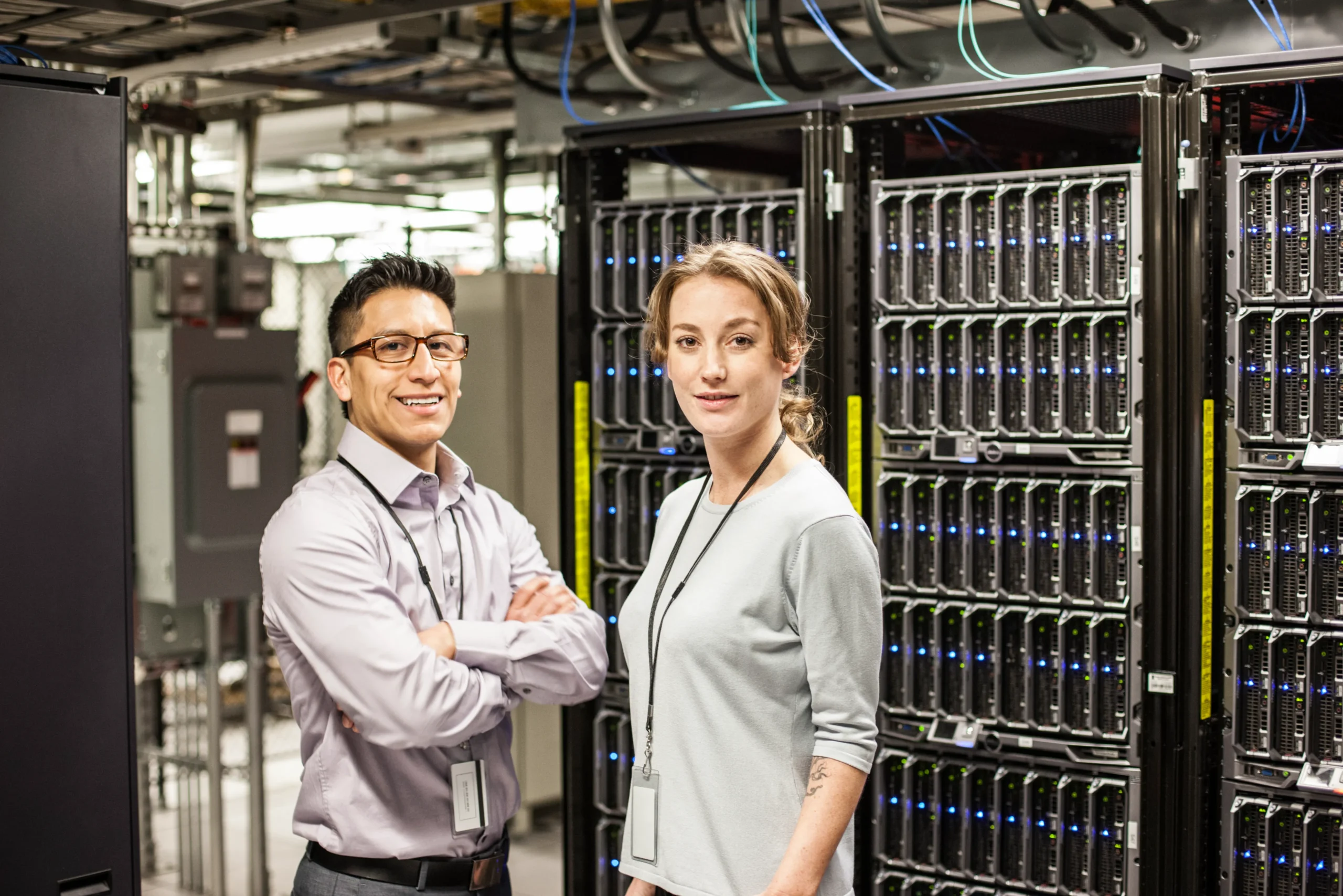 Two IT technicians managing server racks for efficient inventory tracking in a data center.