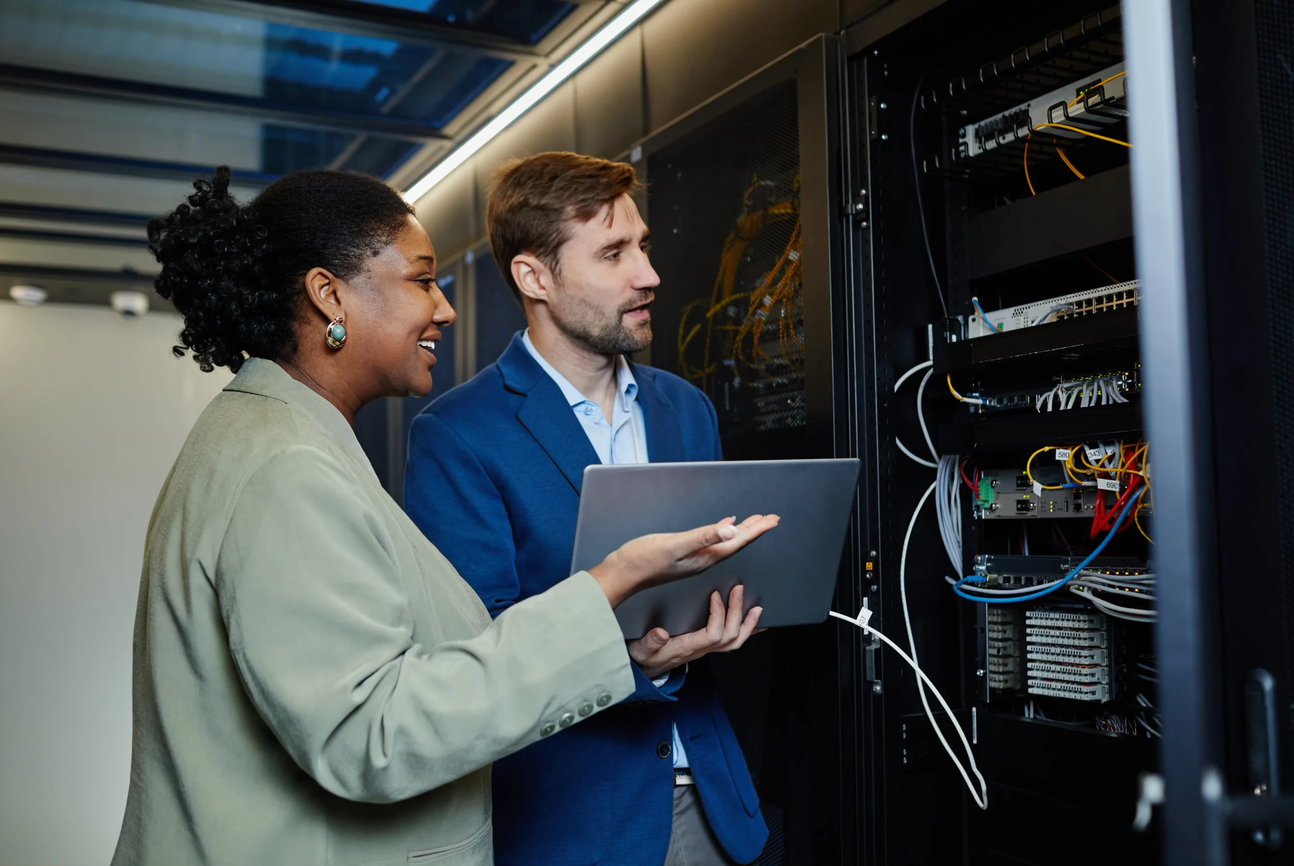 Cybersecurity experts discussing data security protocols in a high-tech data center environment.