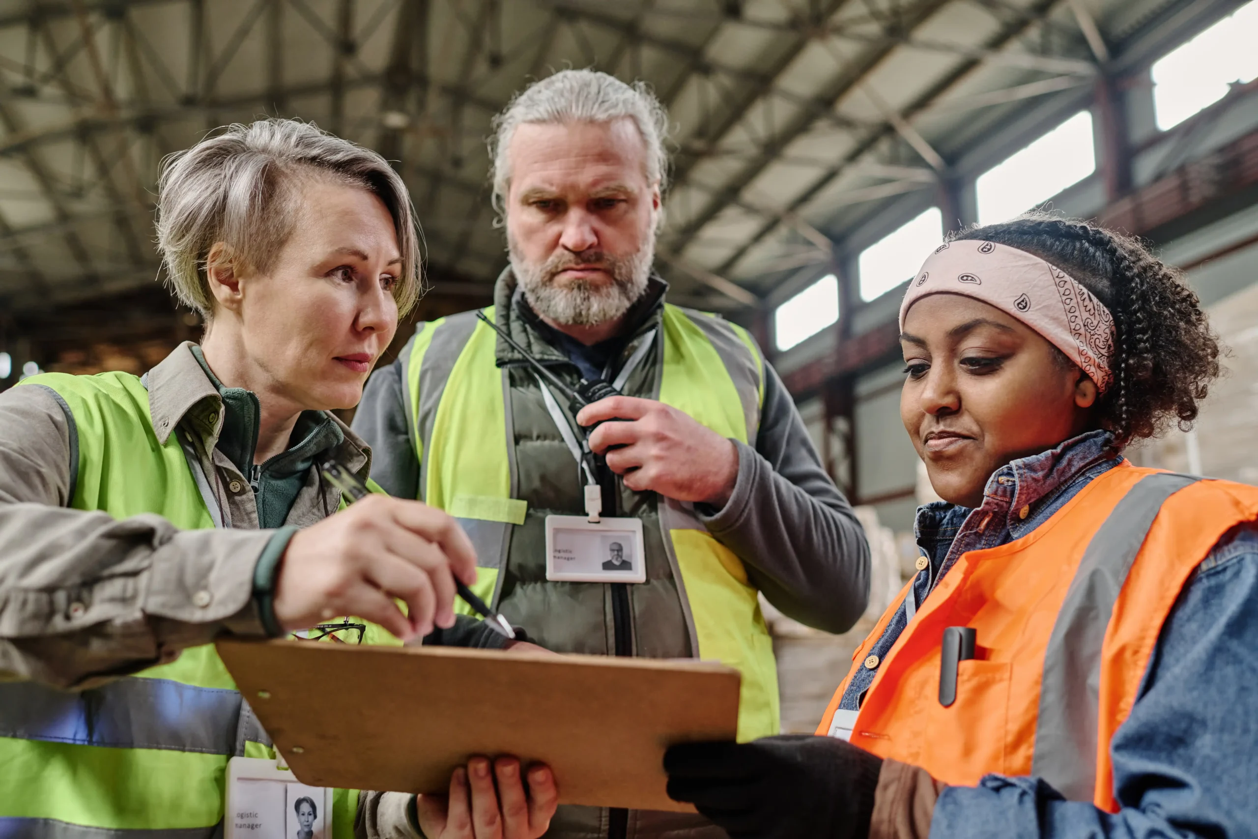 Foreman discussing customs compliance documentation with warehouse workers.