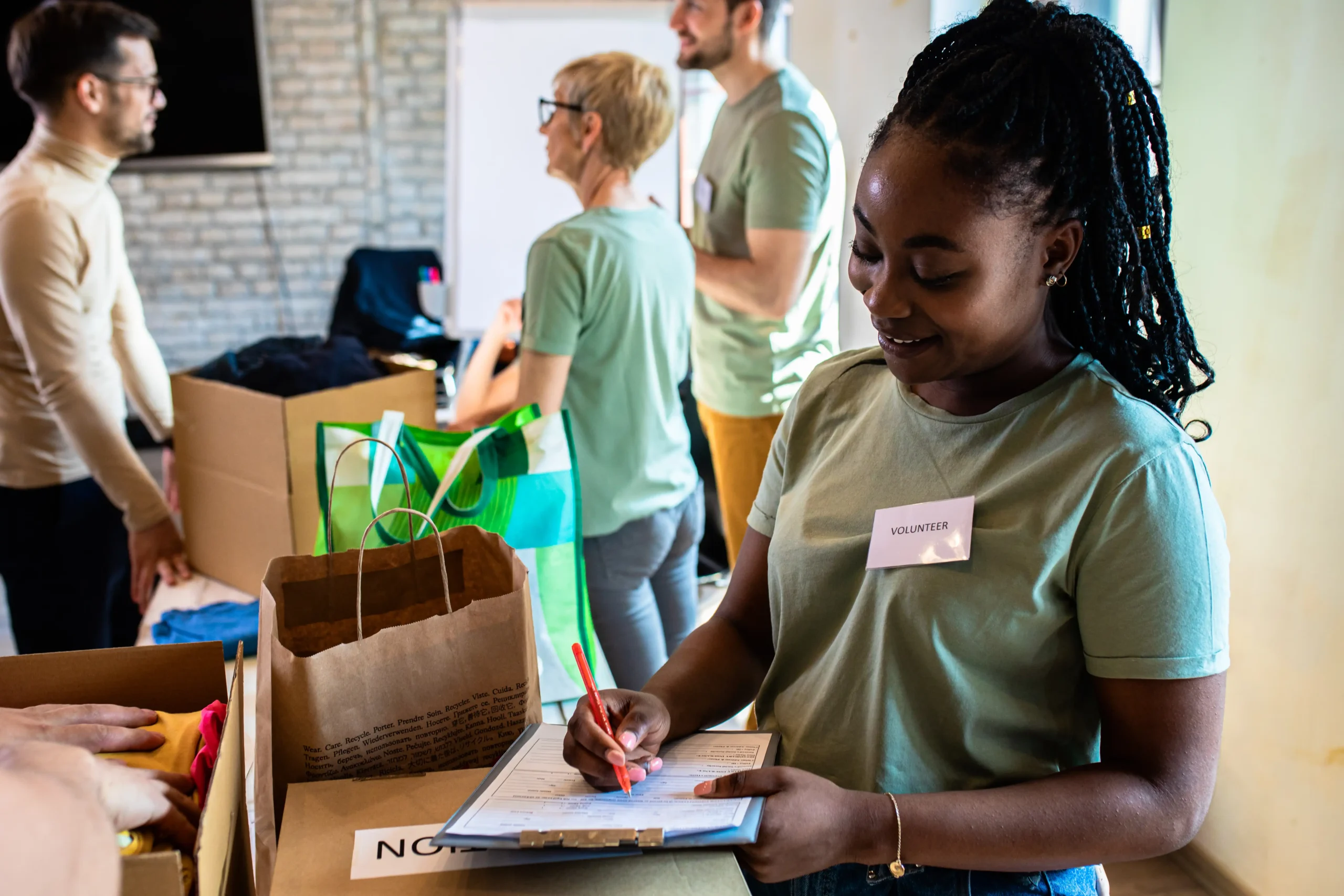 Volunteers organizing donations in a community center, showcasing sustainable practices in logistics and packaging.