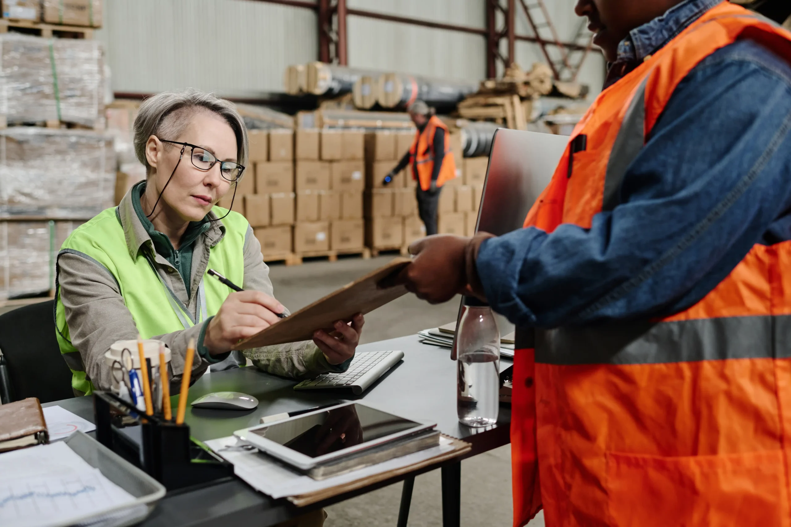 Warehouse manager signing delivery documents for import/export operations.