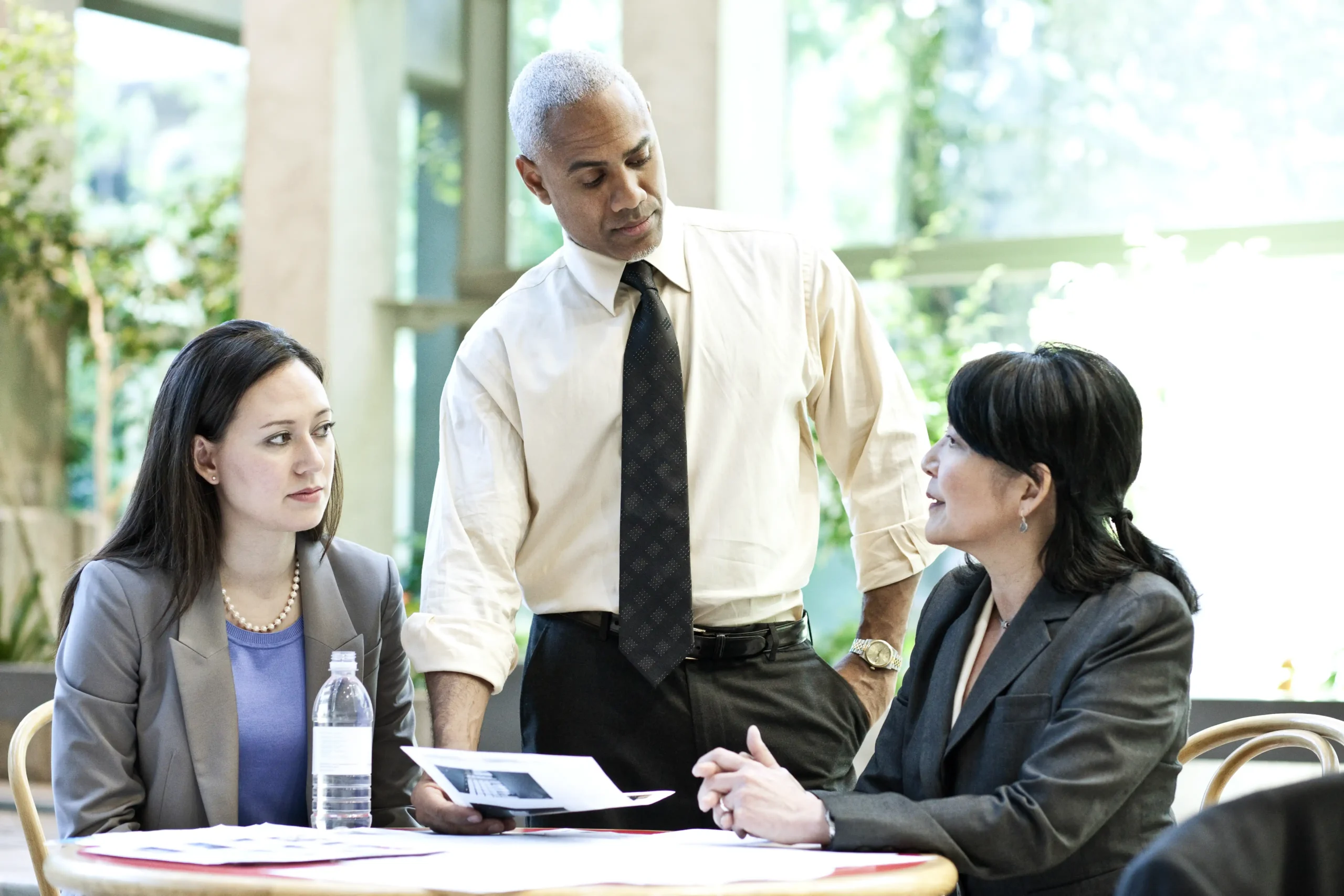 Diverse group of professionals discussing informal strategies for risk mitigation in a business setting.