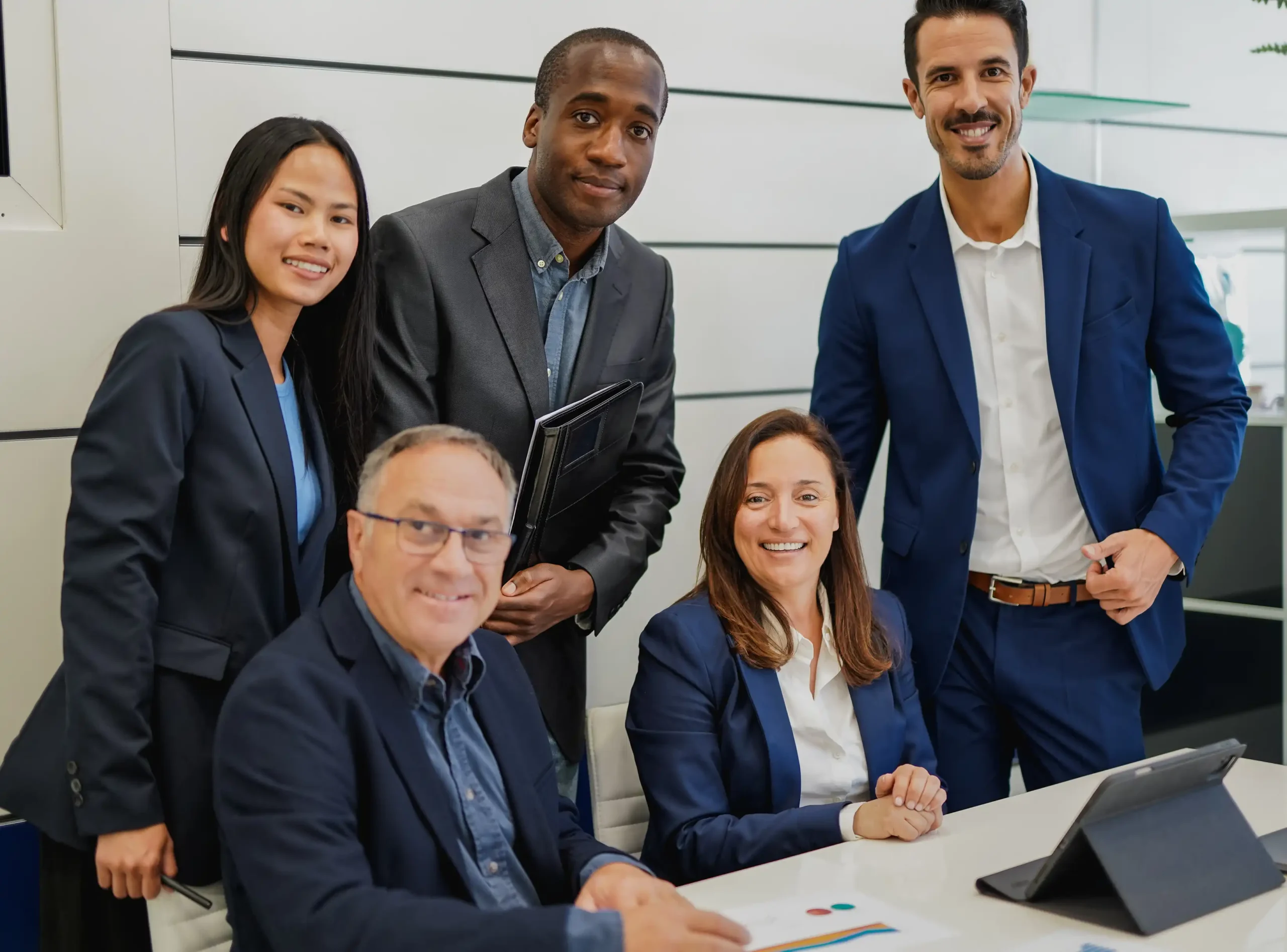 Business team smiling in the office after a successful risk management planning session.