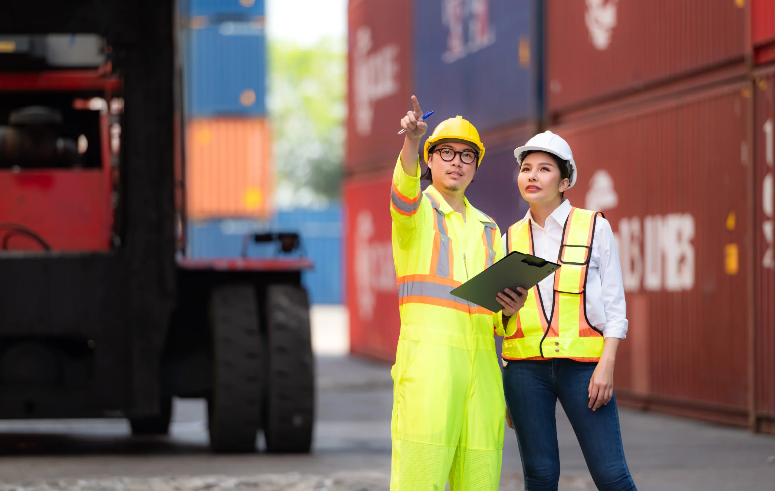 Logistics engineers inspecting a shipping yard for container management and supply chain optimization.