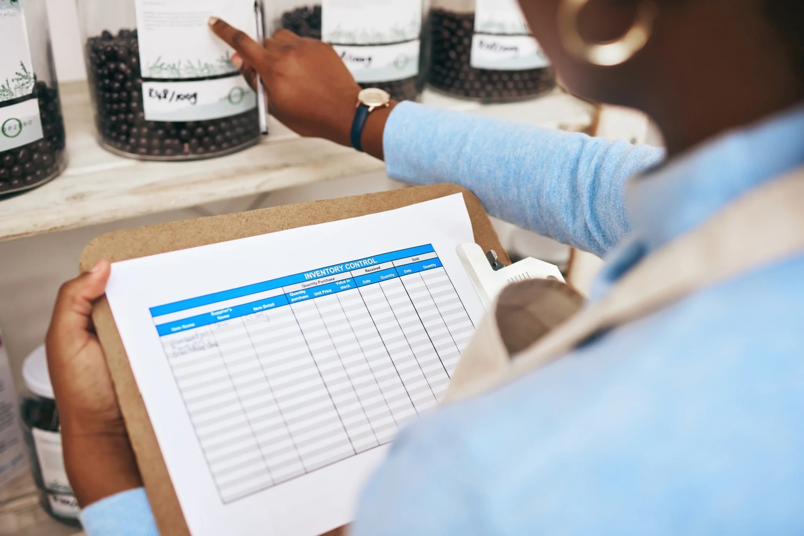 Quality control specialist updating inventory tracking paperwork in a warehouse.