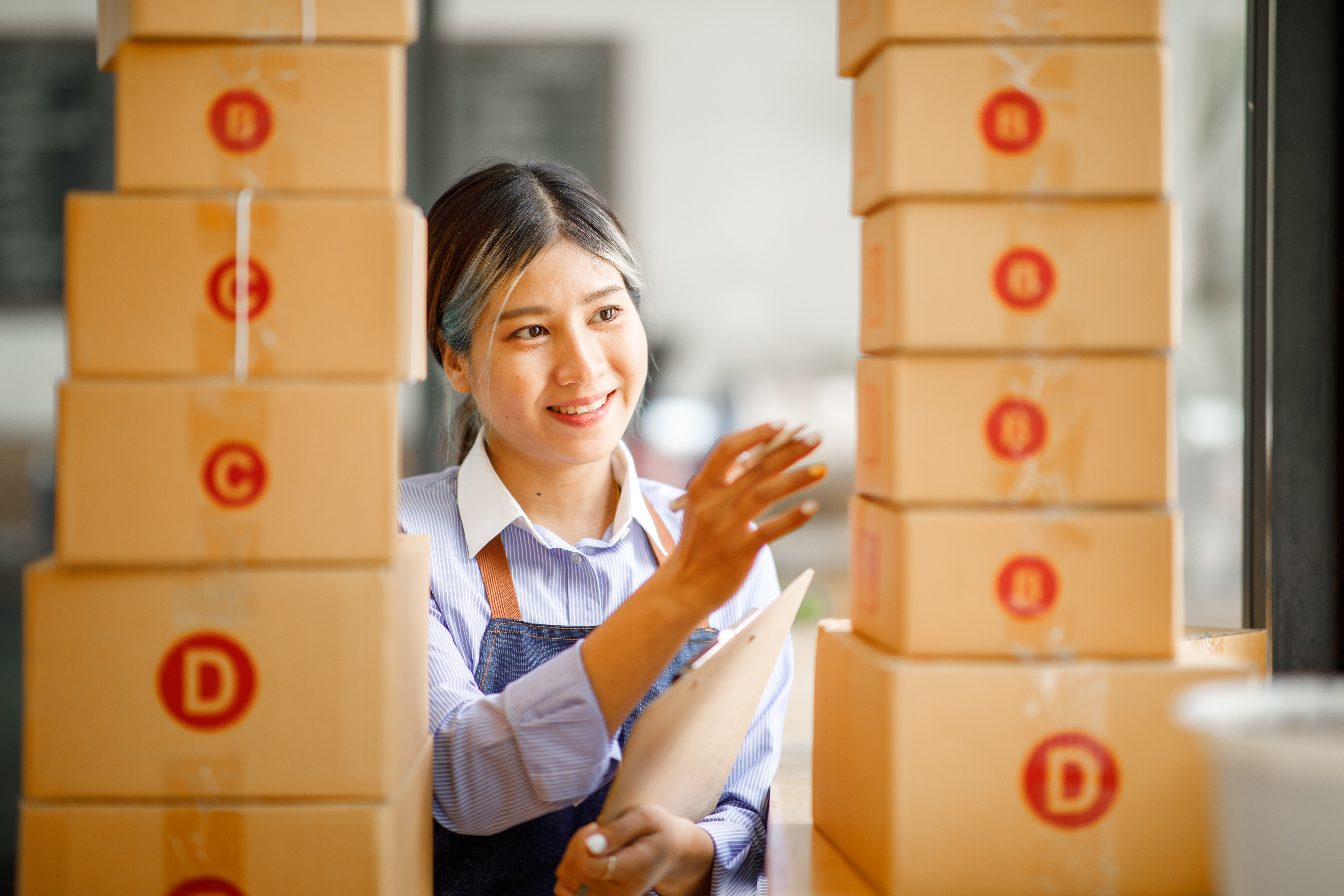 Entrepreneur organizing stacked packages in an order fulfillment process for small business success.