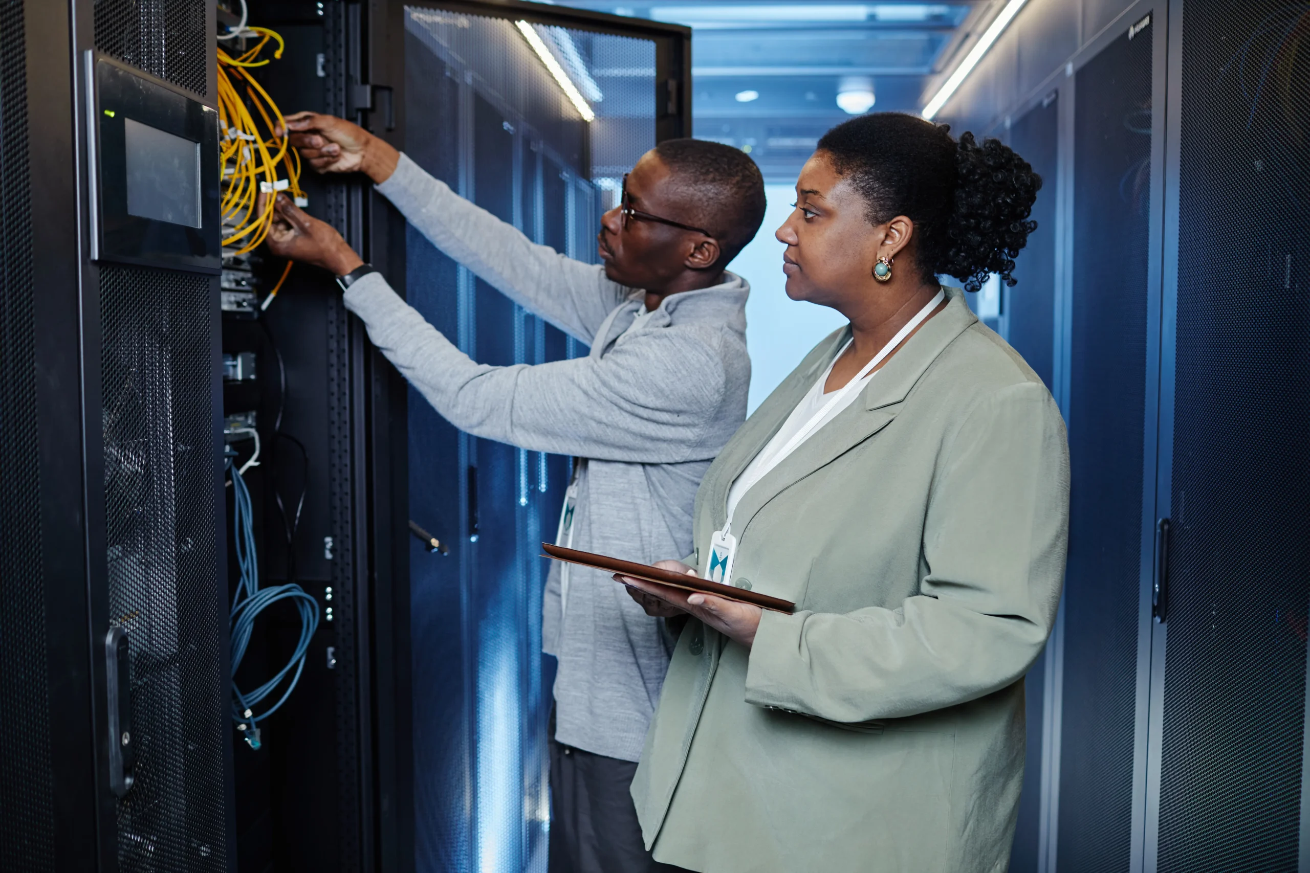 System administrators setting up network cables to improve data accuracy for inventory tracking.