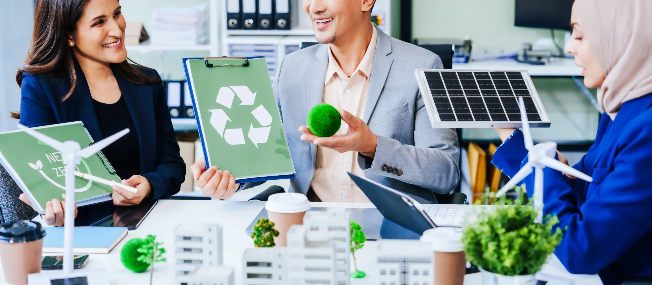 Team of professionals discussing renewable energy and recycling solutions in a green office environment.