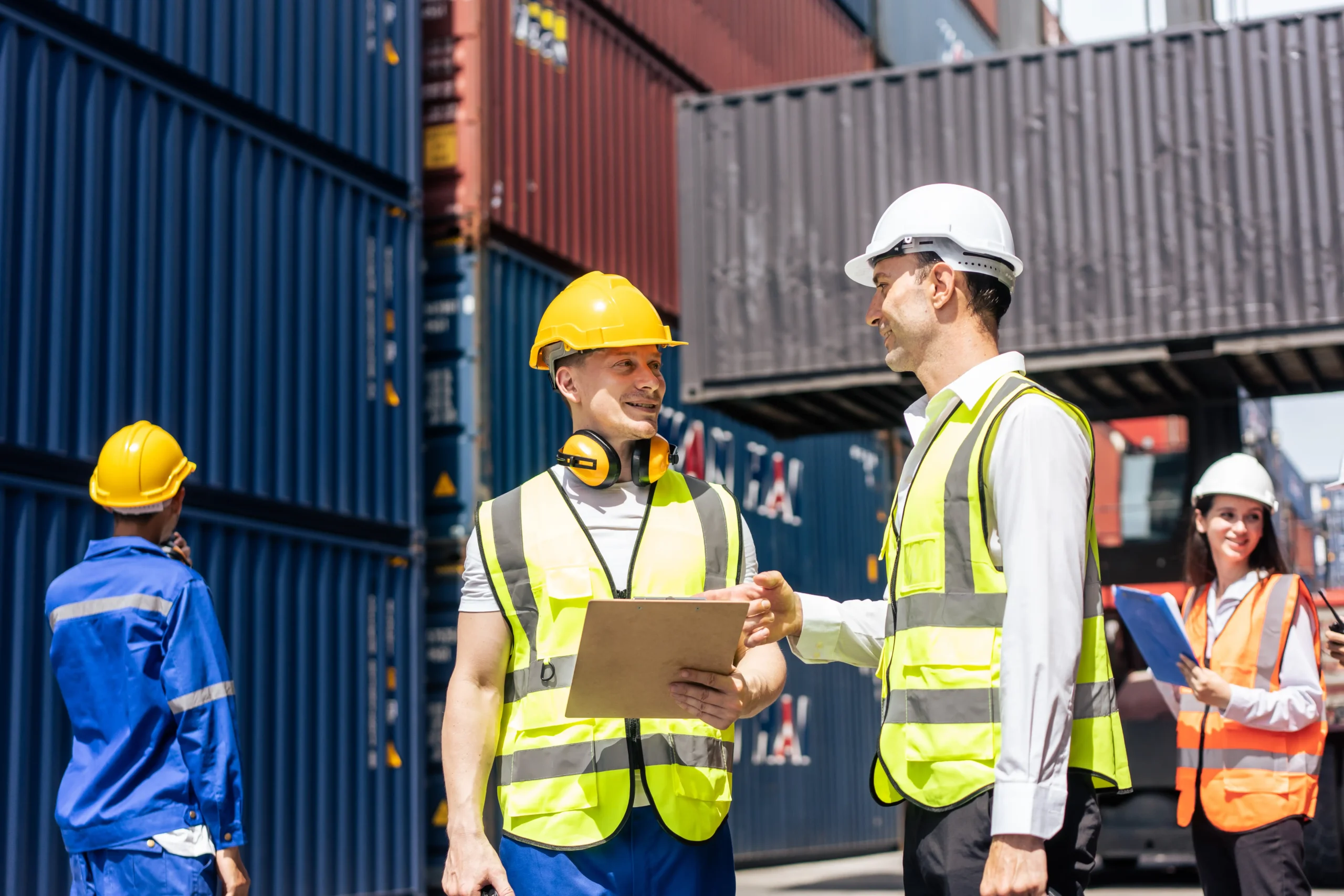 Two businessmen coordinating tariff management strategies near a container terminal to ensure smooth trade operations.