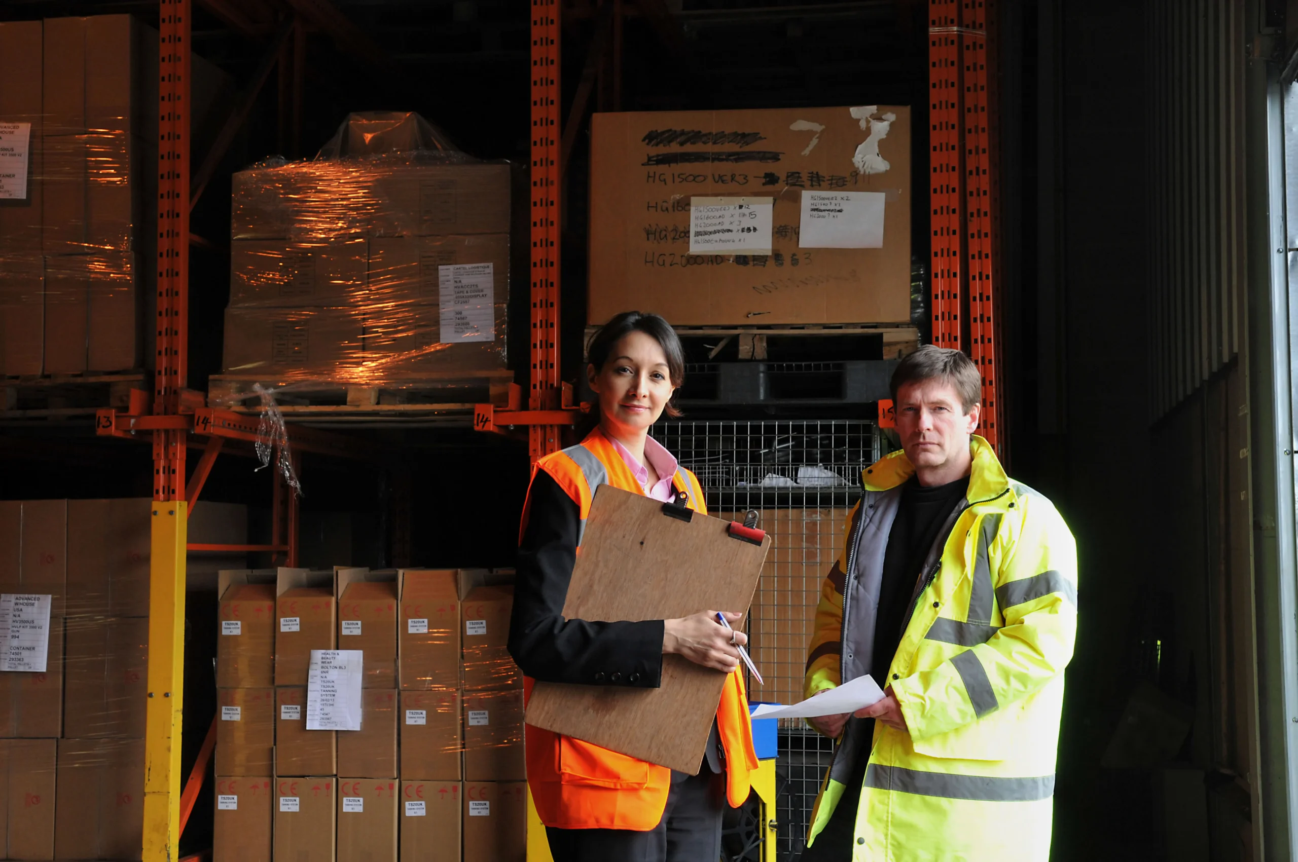 Warehouse colleagues reviewing inventory for customs compliance verification.