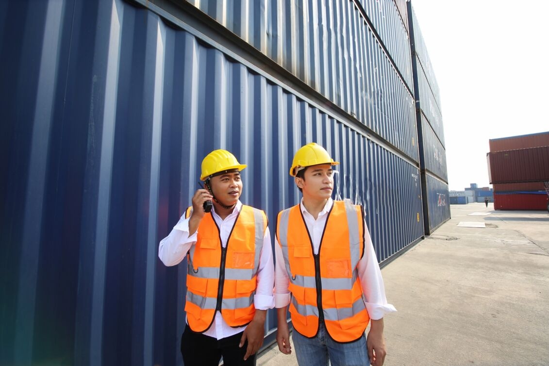 Two logistics managers supervising container operations in a Foreign-Trade Zone.