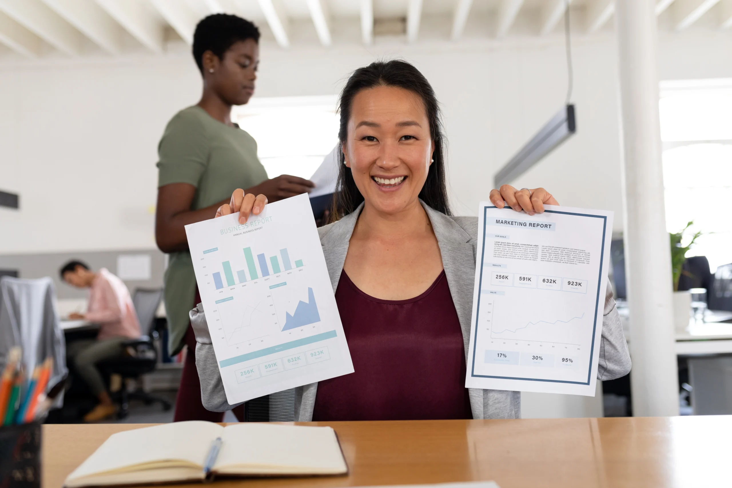 A smiling businesswoman showcasing marketing and business performance reports, highlighting the visual benefits of custom reporting tools