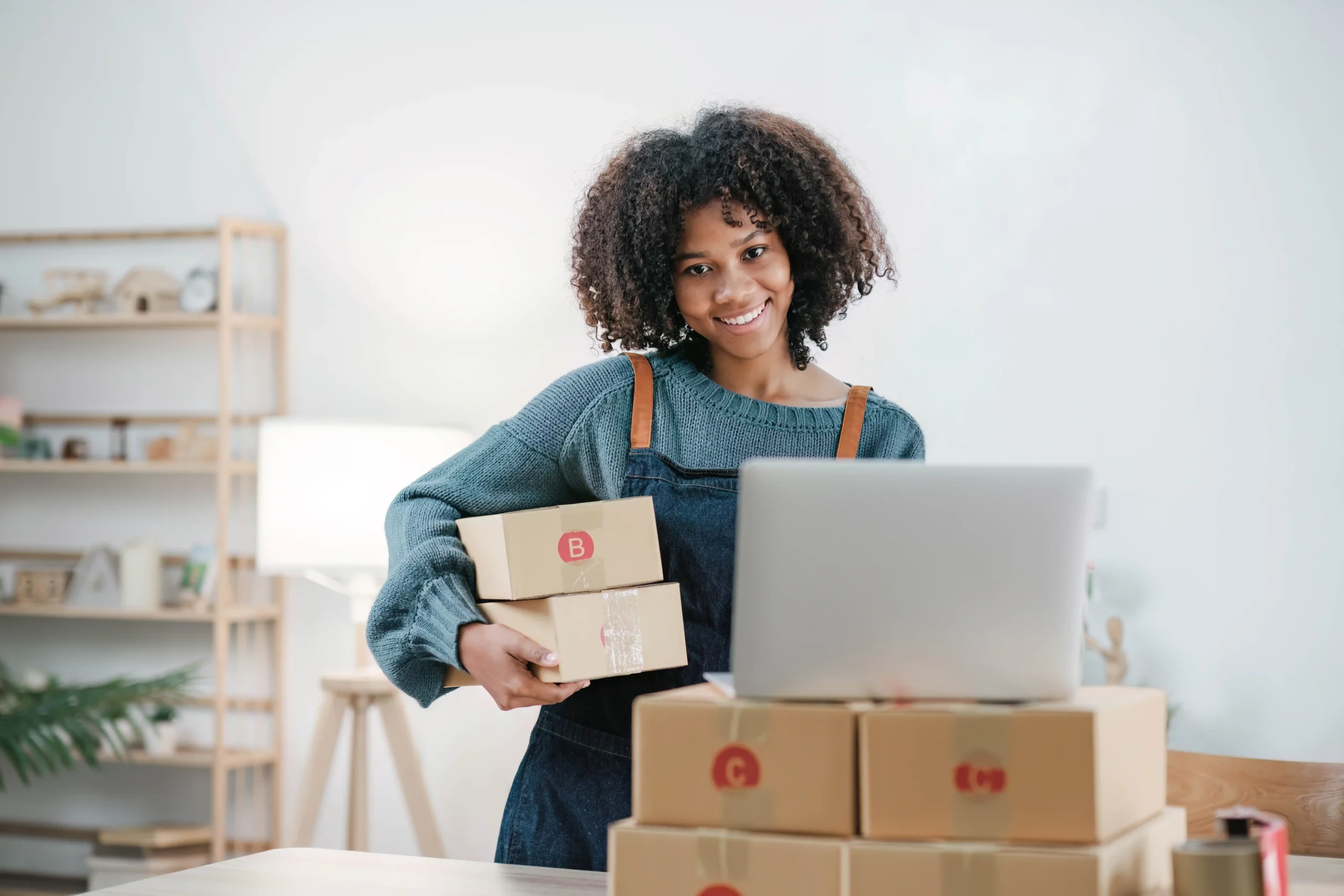 Asian entrepreneur managing small business inventory and preparing shipments with a smile.