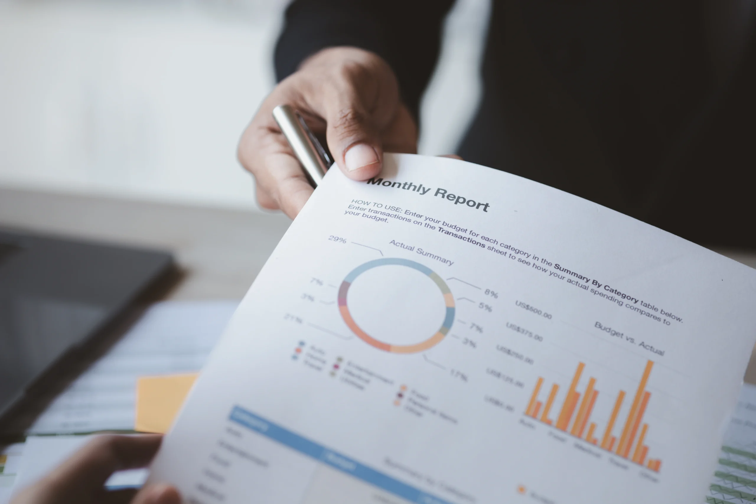 Close-up of a businessman presenting a monthly report with bar and pie charts, showcasing the effectiveness of customized data visualization.