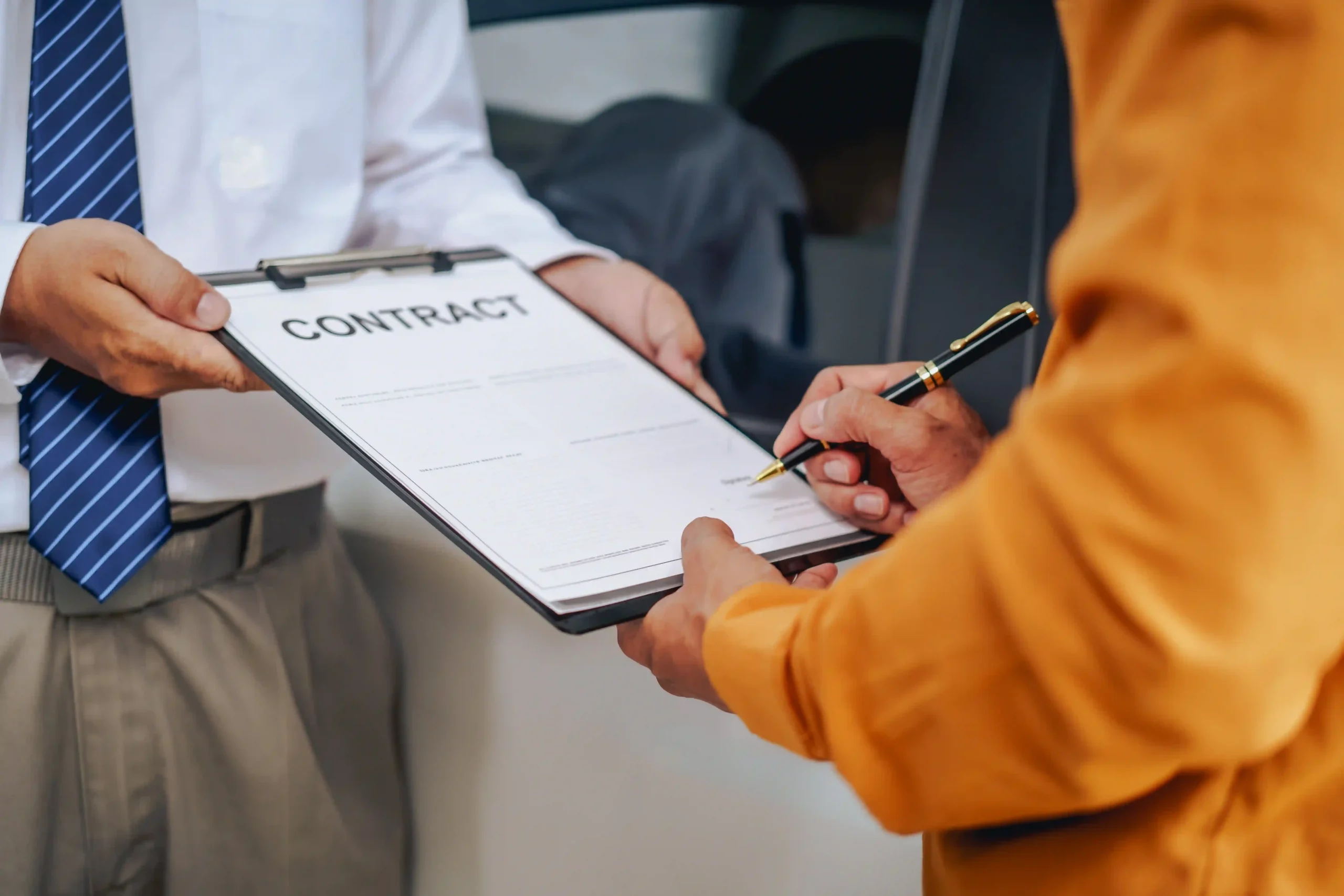 A logistics professional signs a logistics contract agreement on a clipboard, finalizing a business deal with a provider in a formal setting.