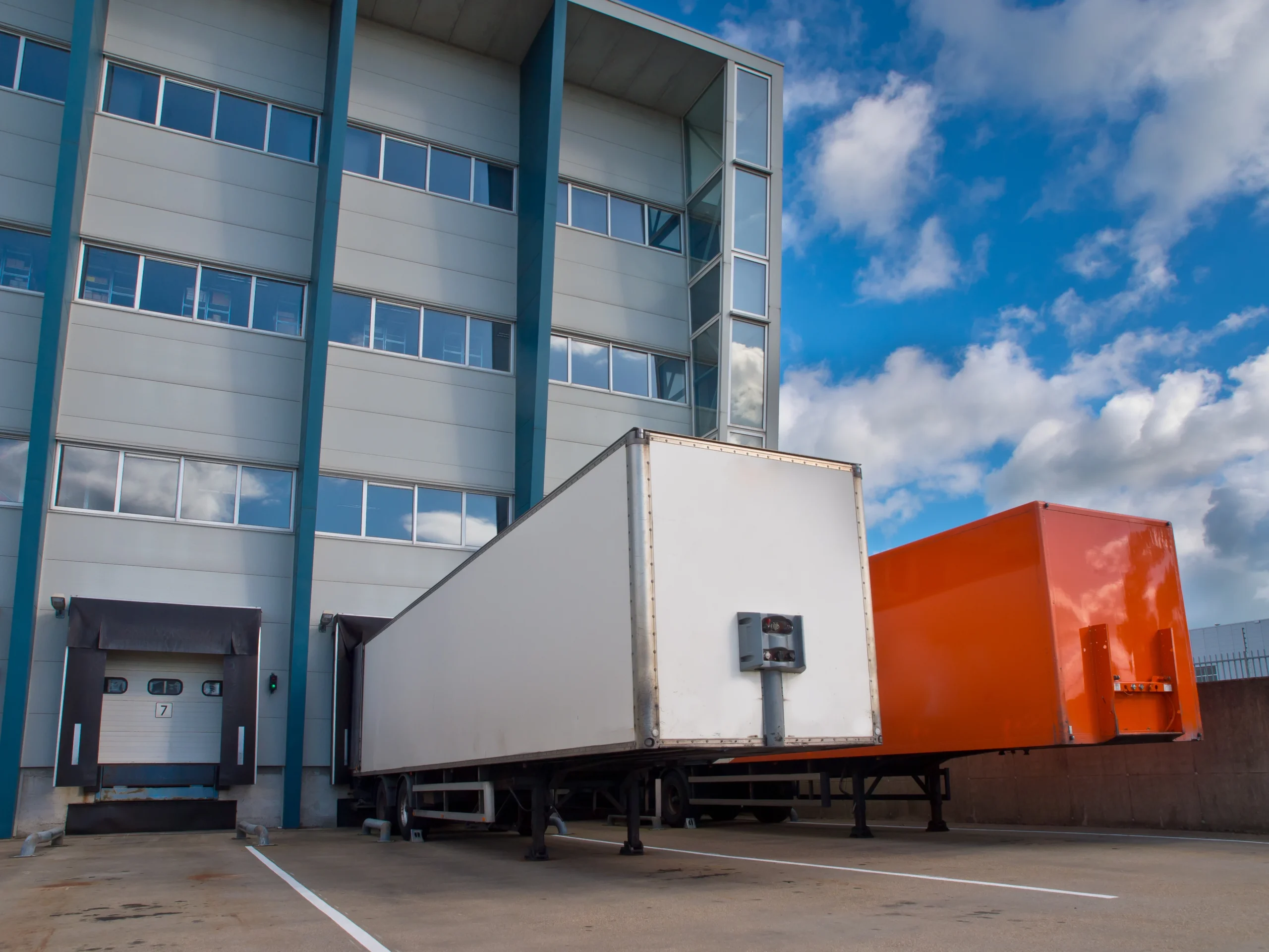 Distribution center loading dock with trailers positioned for cross docking and streamlined sorting operations.