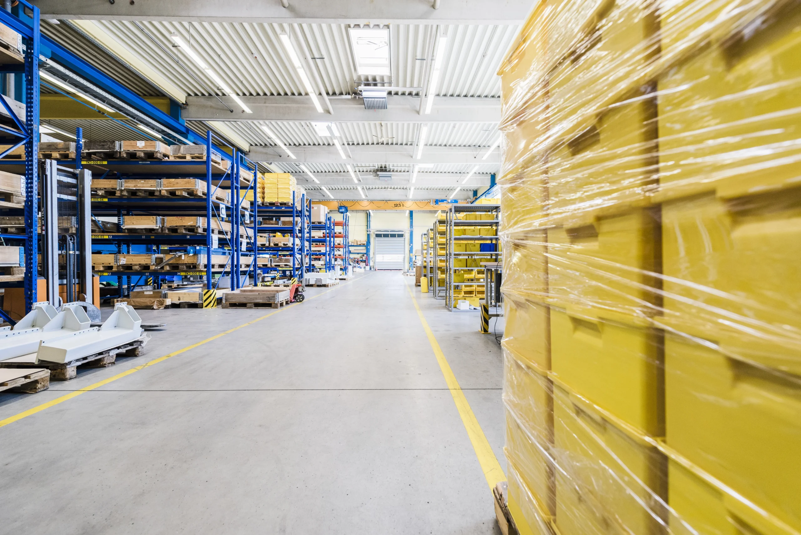 Well-organized warehouse with neatly stacked pallets and ample space for cross-docking operations.