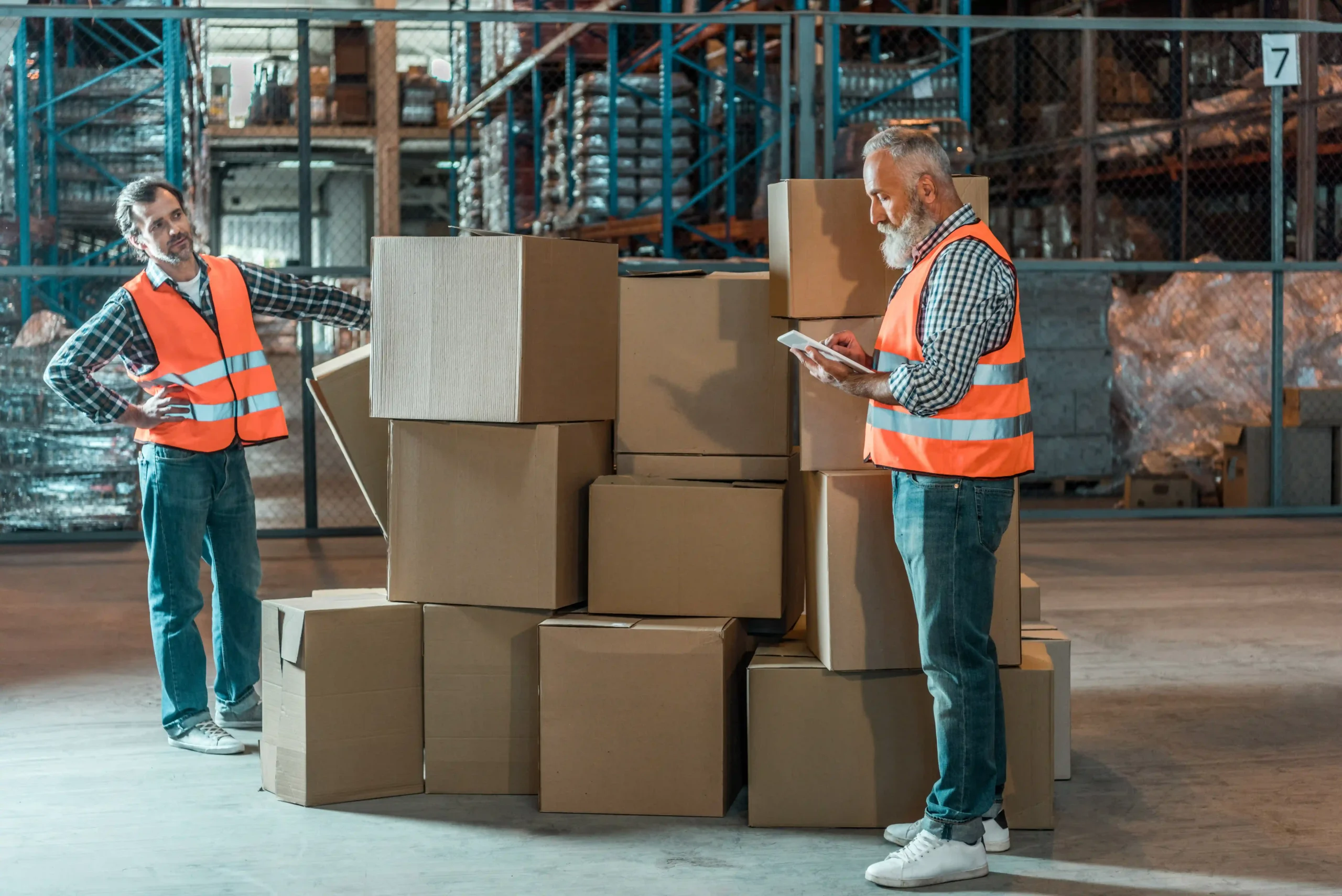 Two warehouse workers inspecting a shipment of boxes in a dedicated saline storage facility.