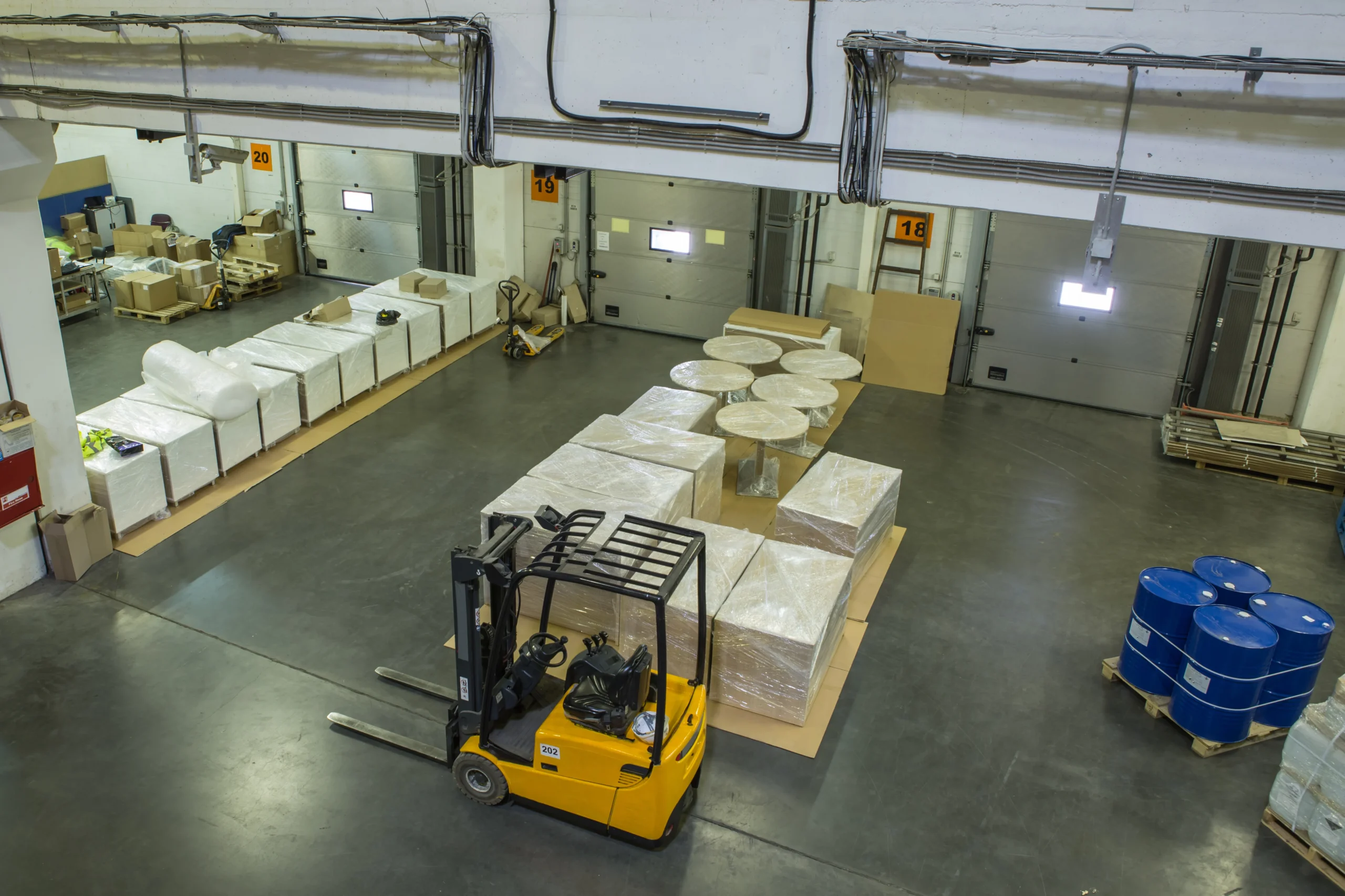 Interior of a cross-docking area with forklift and pallets ready for shipment, highlighting organized logistics operations.