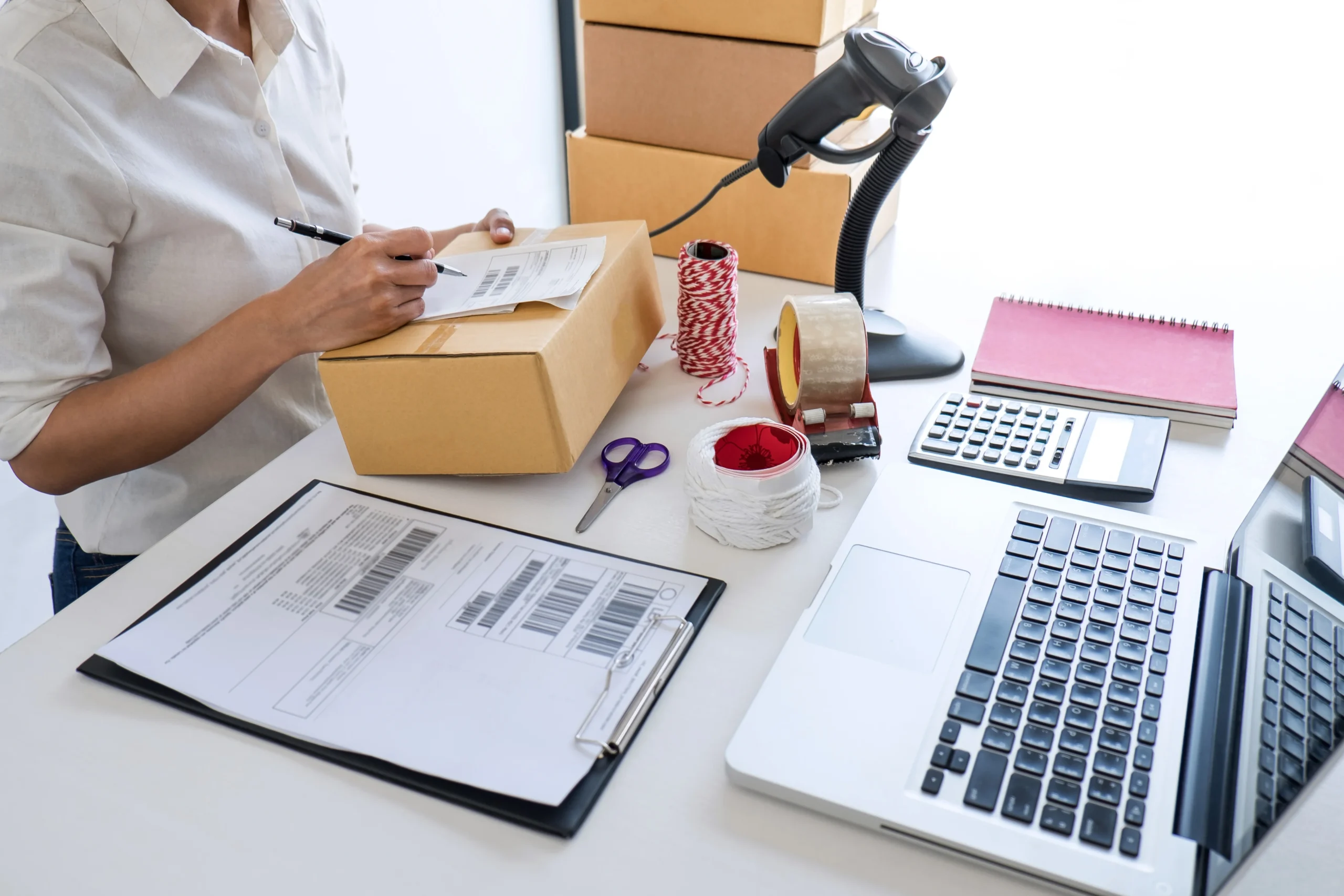 Worker labeling and scanning e-commerce shipment boxes during the order fulfillment process.