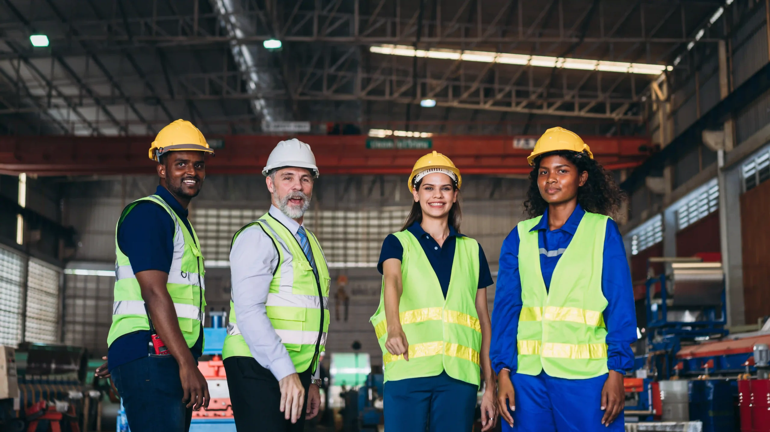 A group of FTZ Coordinators and engineers stacking hands in a warehouse, emphasizing teamwork and coordination in global trade compliance.