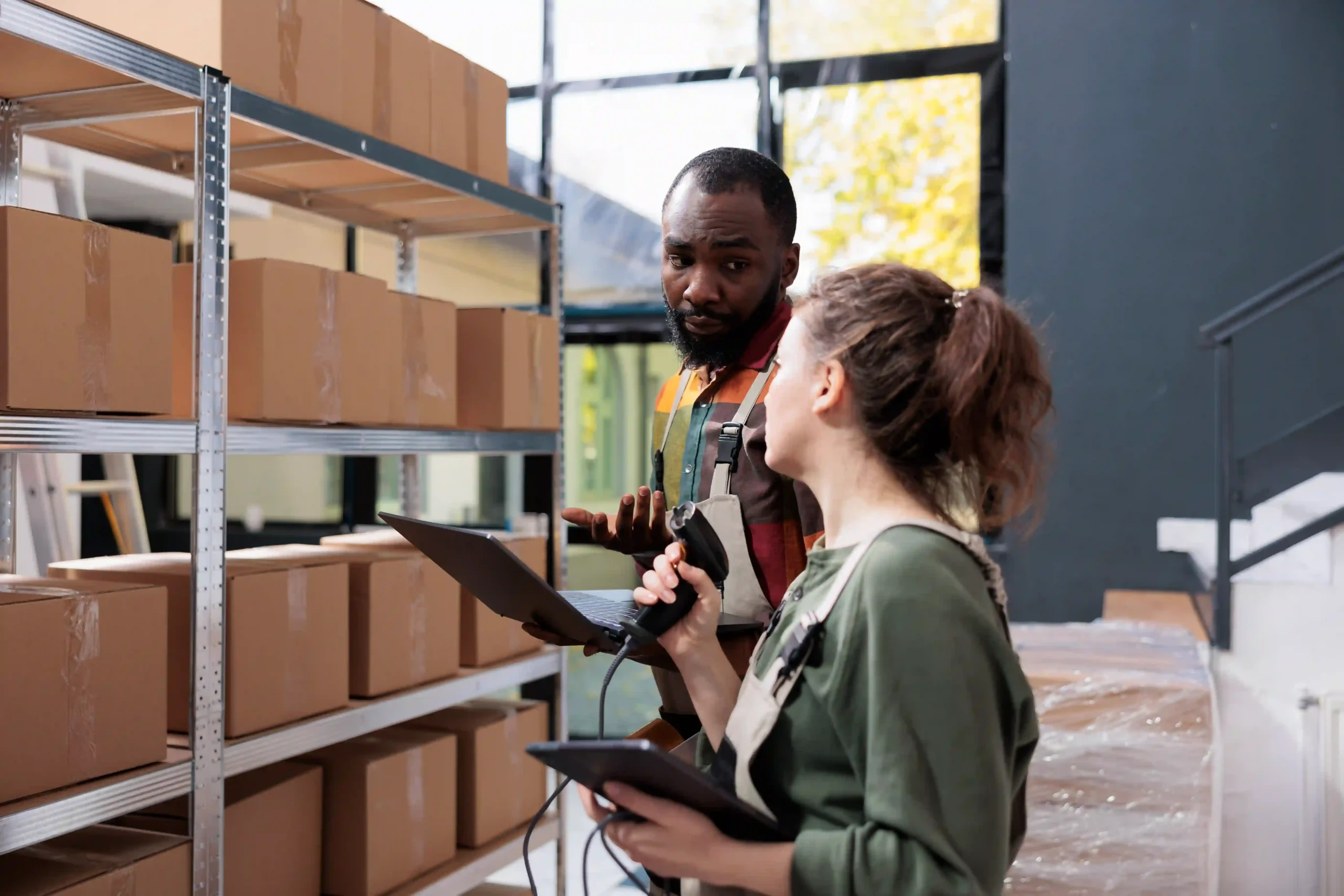 A stockroom supervisor presenting a package for quality check in a well-organized storage facility.