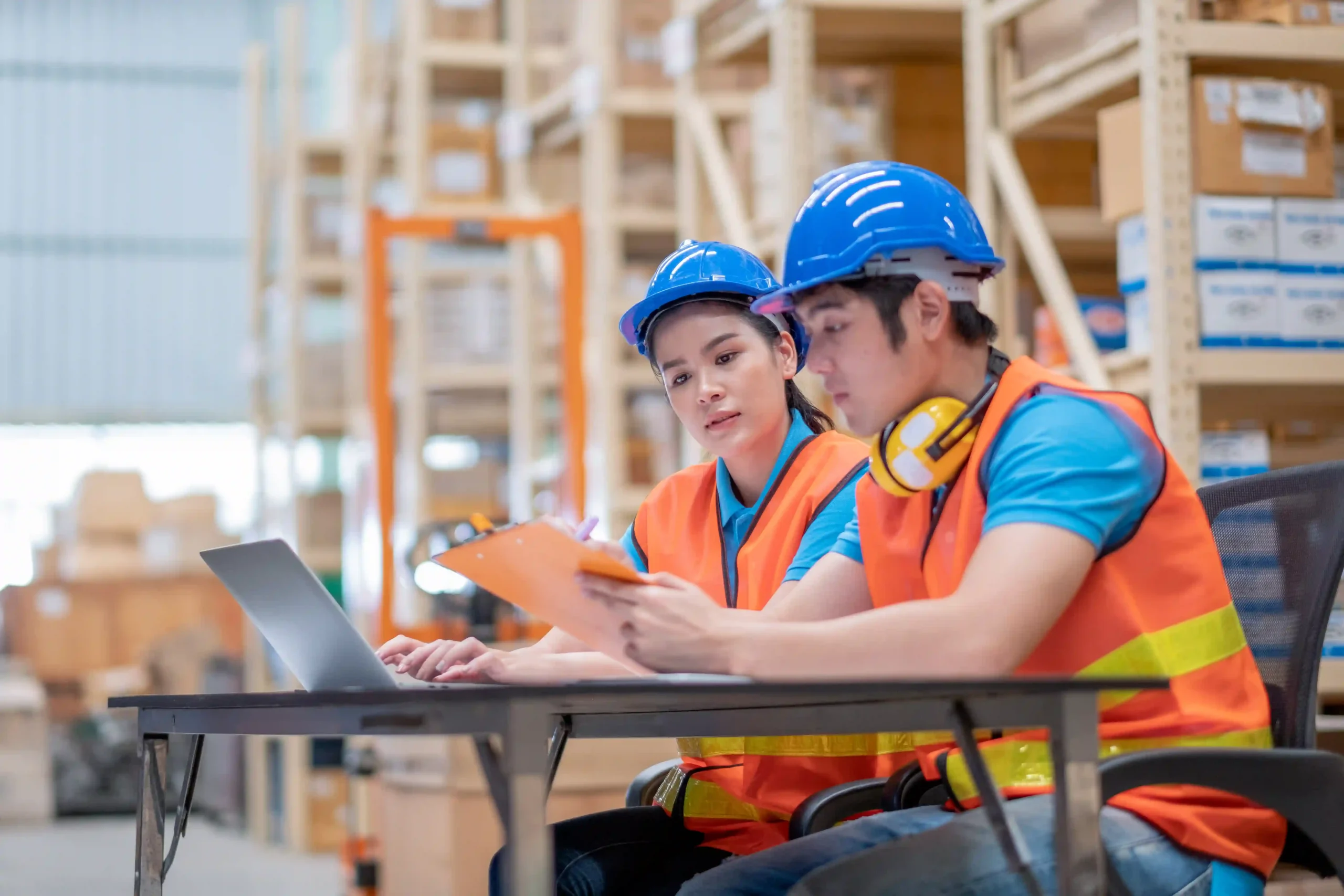 Warehouse staff analyzing inventory data to optimize stock levels and enhance supply chain cost optimization.