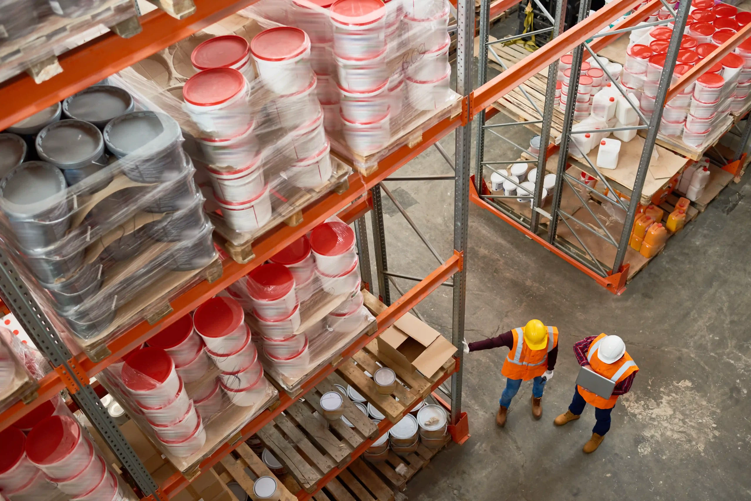 Overhead view of warehouse workers inspecting pallet racks as part of efficient storage solutions for warehouse operations