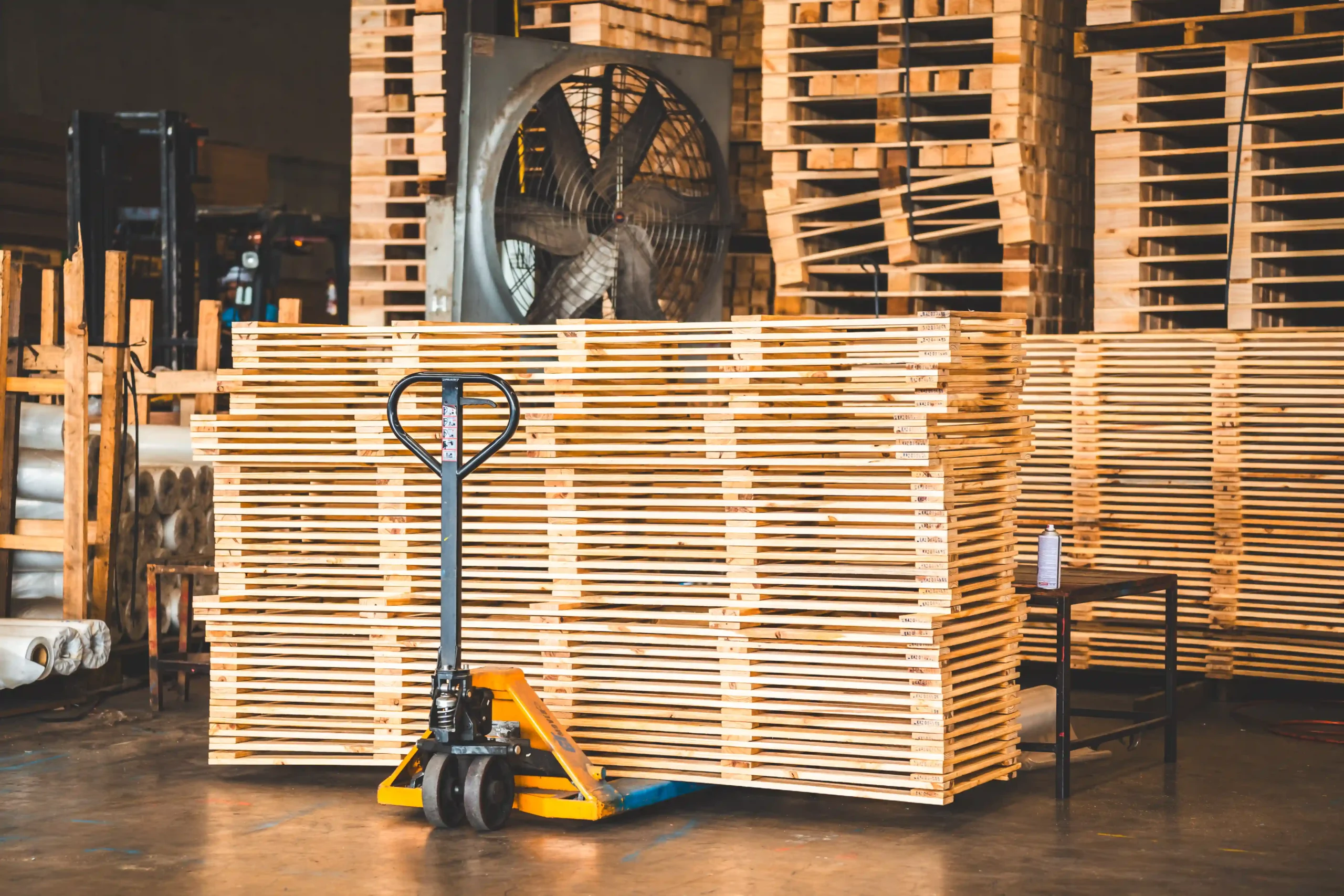 Warehouse pallet unit stacks with pallet jack ready for transport