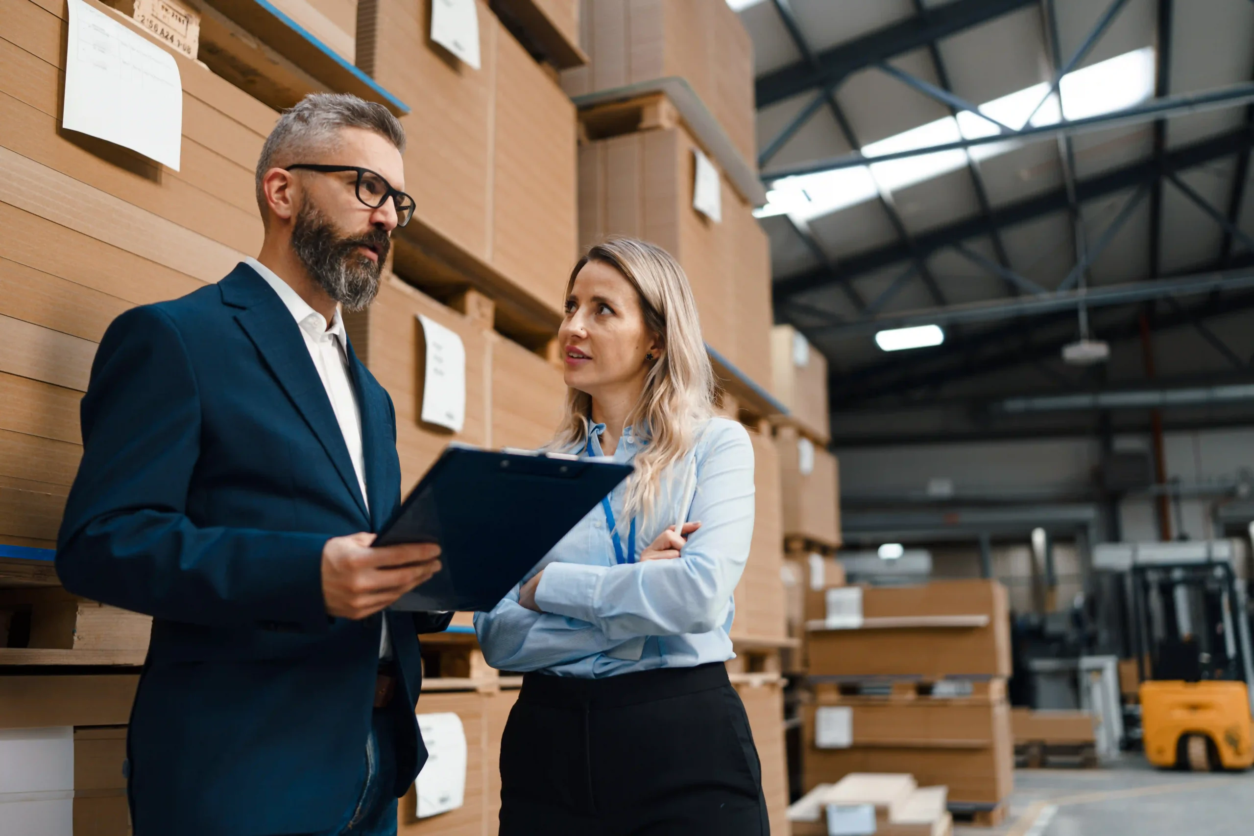 A supply chain optimization manager discussing logistics strategy in a warehouse, improving efficiency and inventory management.