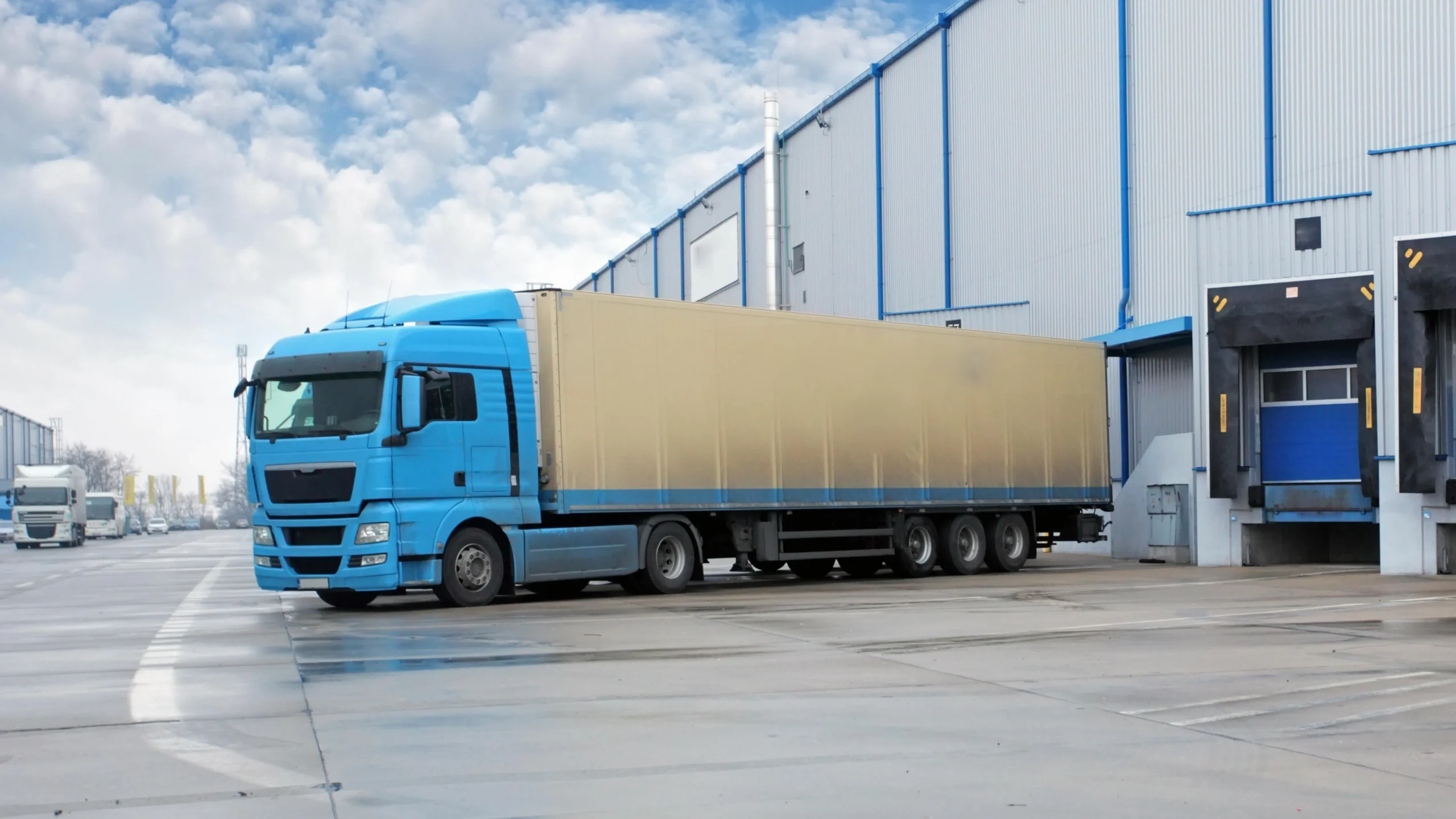Freight truck positioned for cross-docking and transloading outside a logistics facility