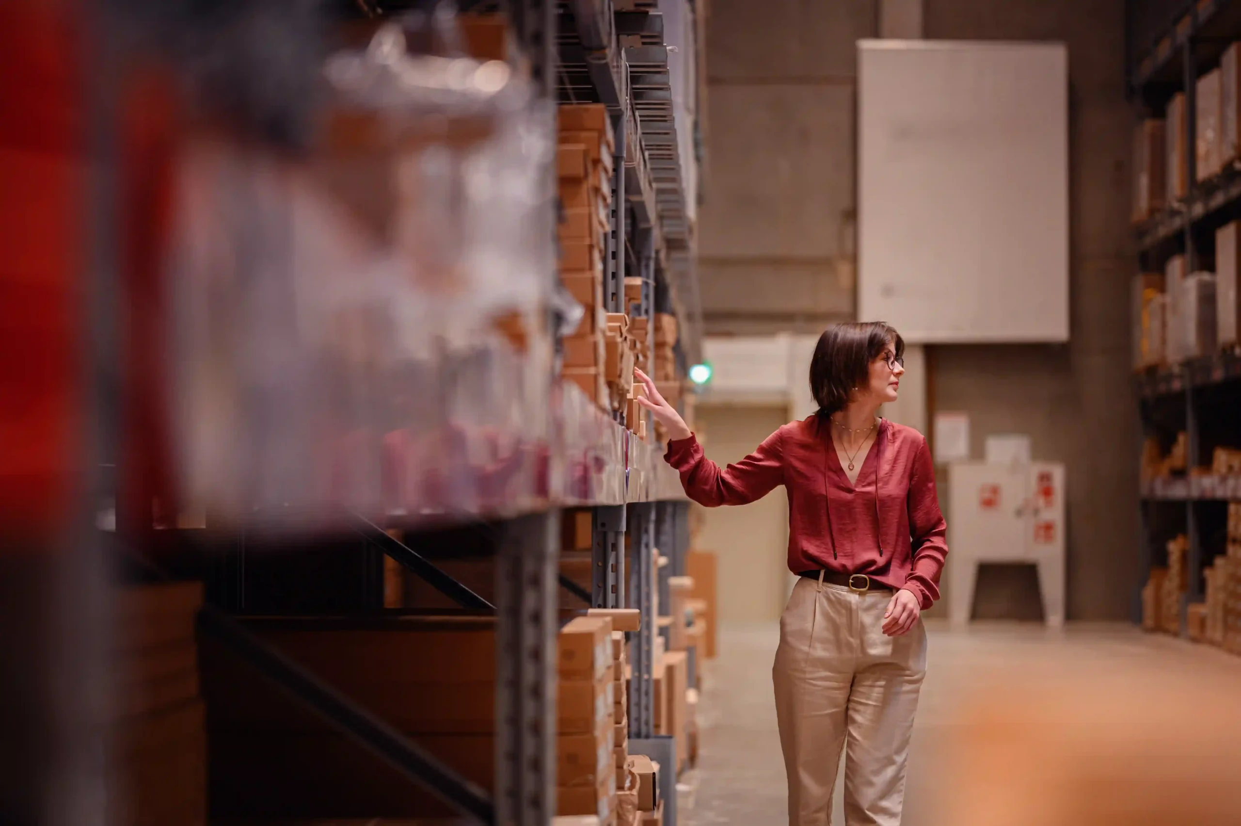 Warehouse manager inspecting static shelving, showcasing one of the common types of storage system in warehouse settings.